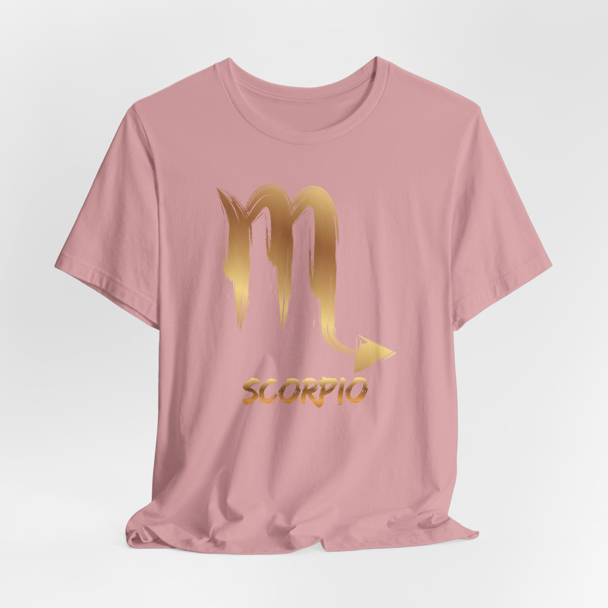 Pink t-shirt with gold Scorpio zodiac design on a light gray background