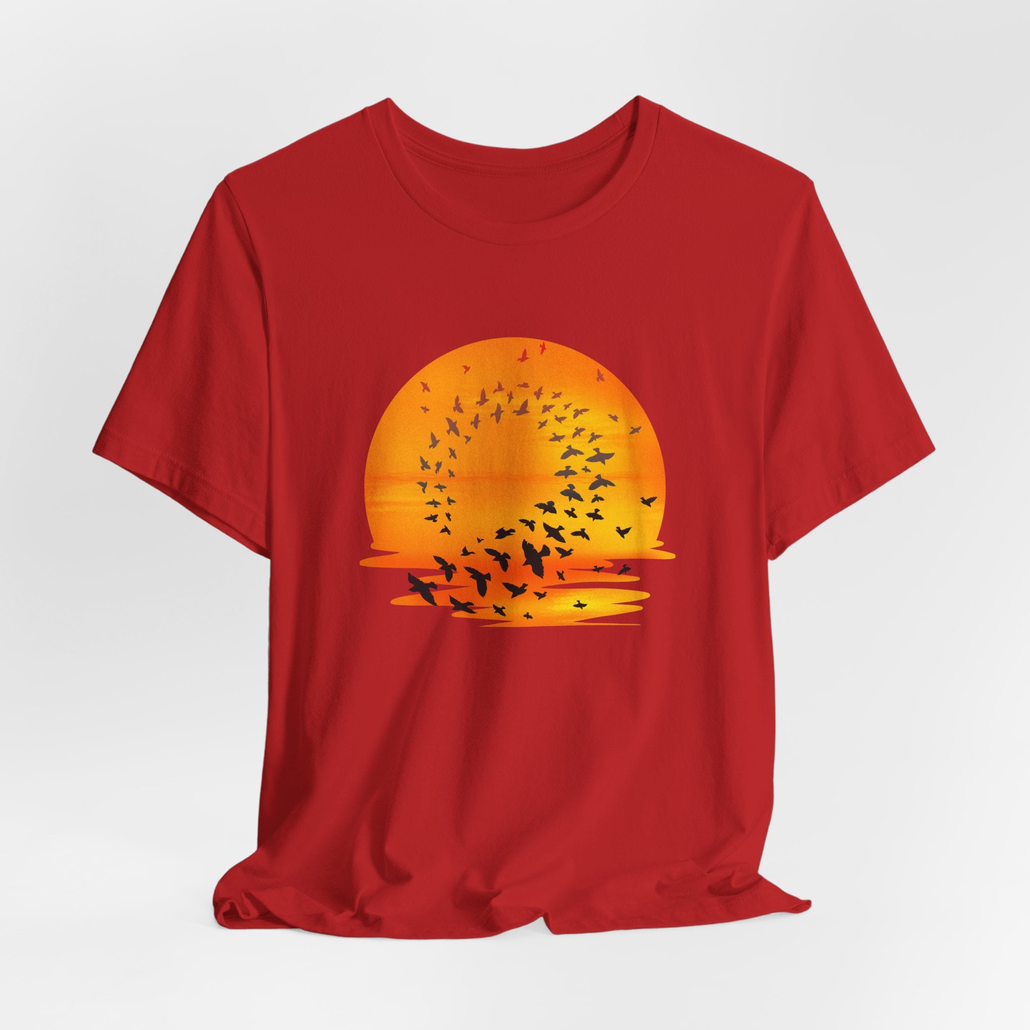 Red t-shirt with a sunset and bird design on a white background