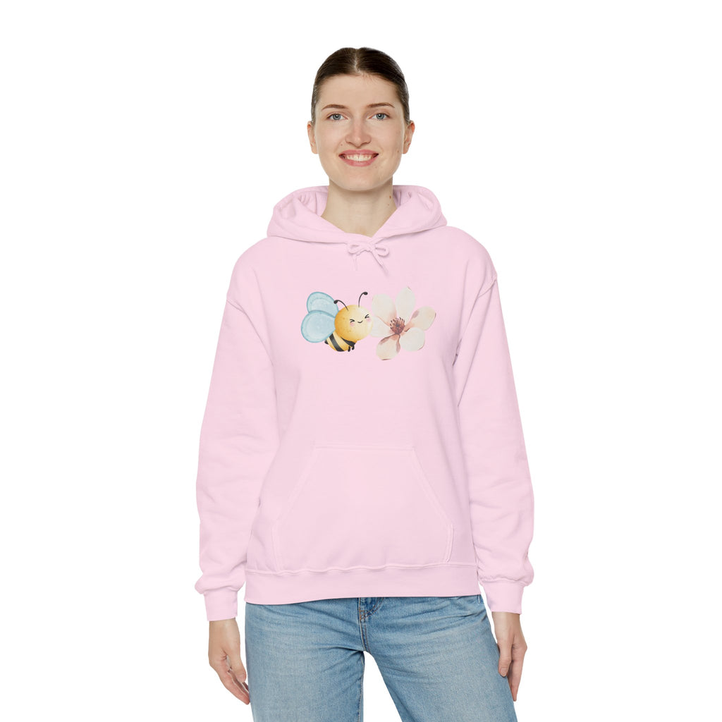 Person wearing a pink hoodie with a flower and bee design on a white background