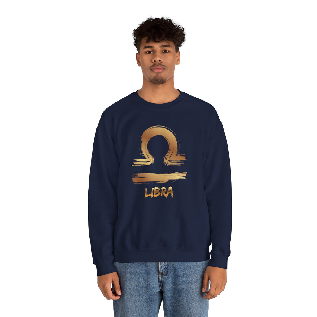 Person wearing a navy blue sweatshirt with a gold Libra zodiac symbol on a white background