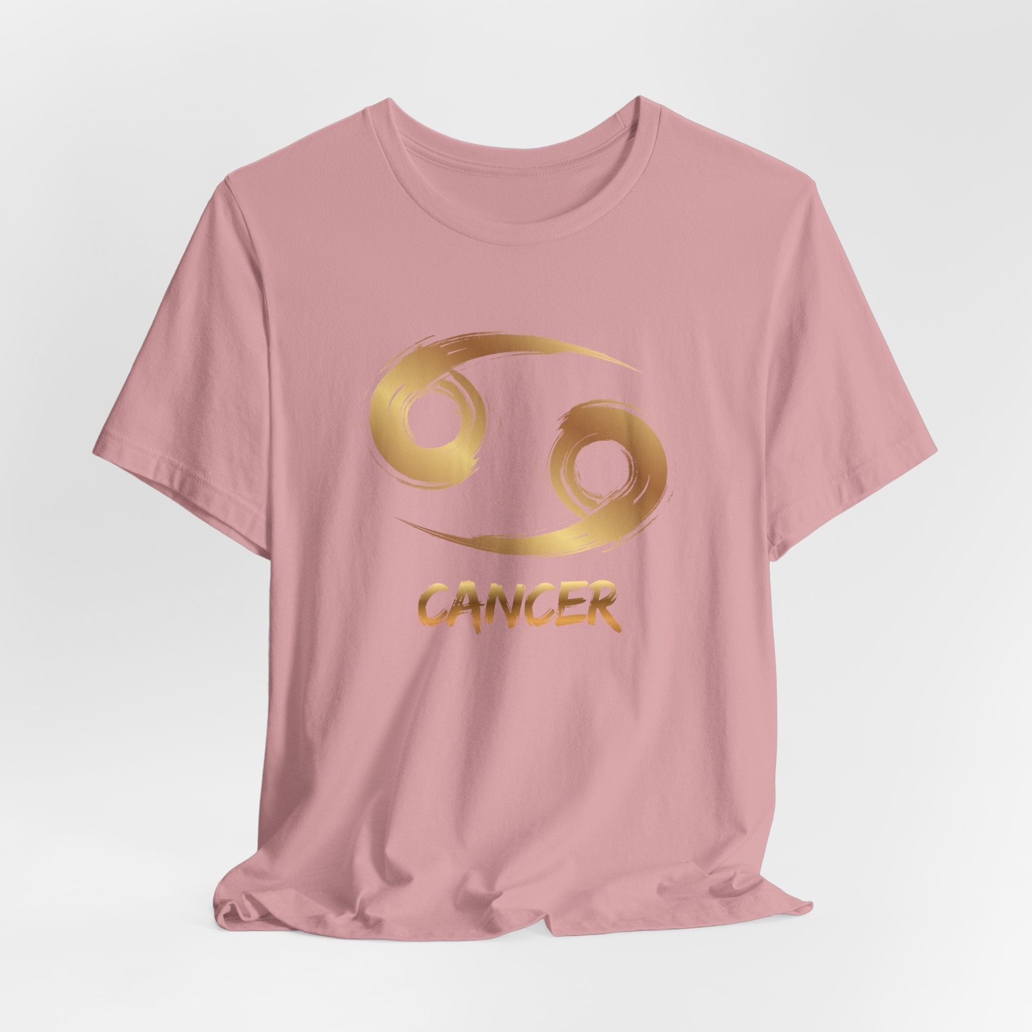 Pink t-shirt with gold Cancer zodiac symbol on a light gray background