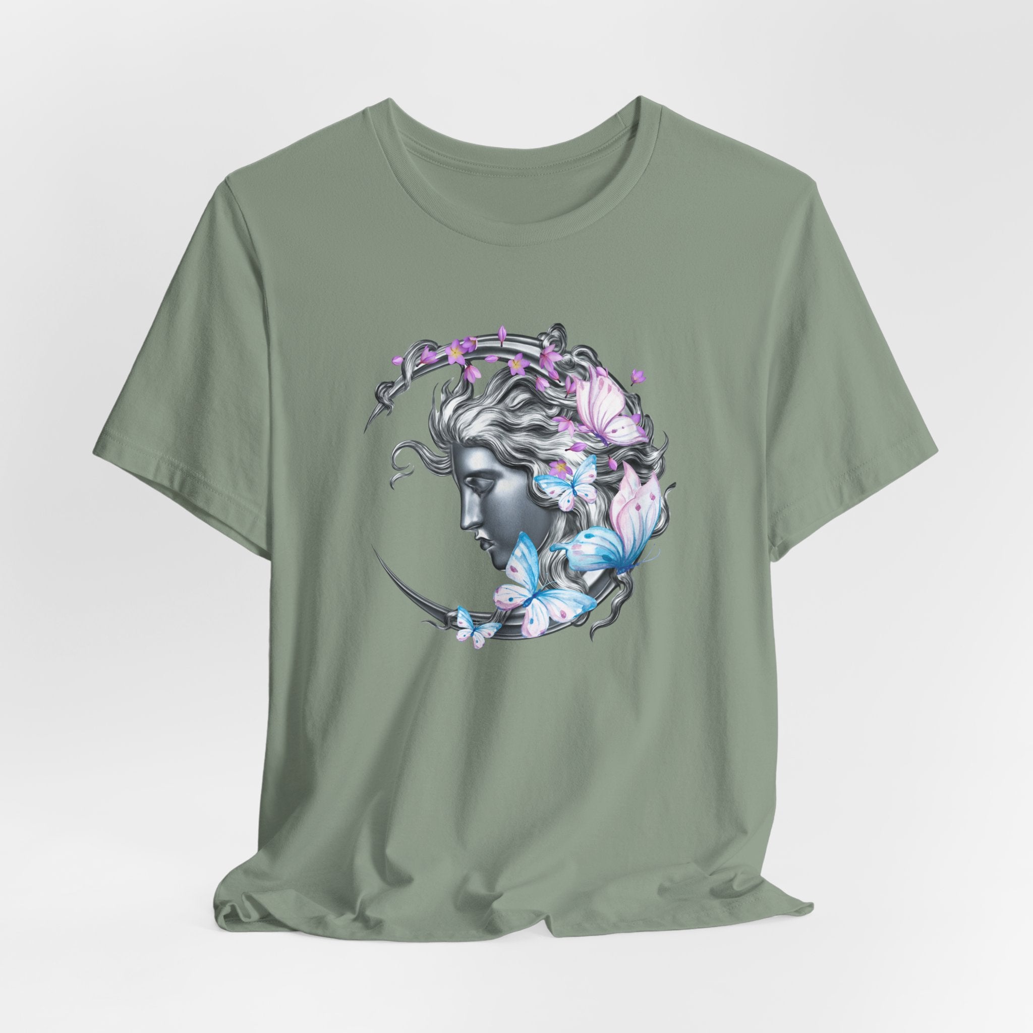 Green t-shirt with a graphic design of a woman's face surrounded by flowers and butterflies on a light gray background.