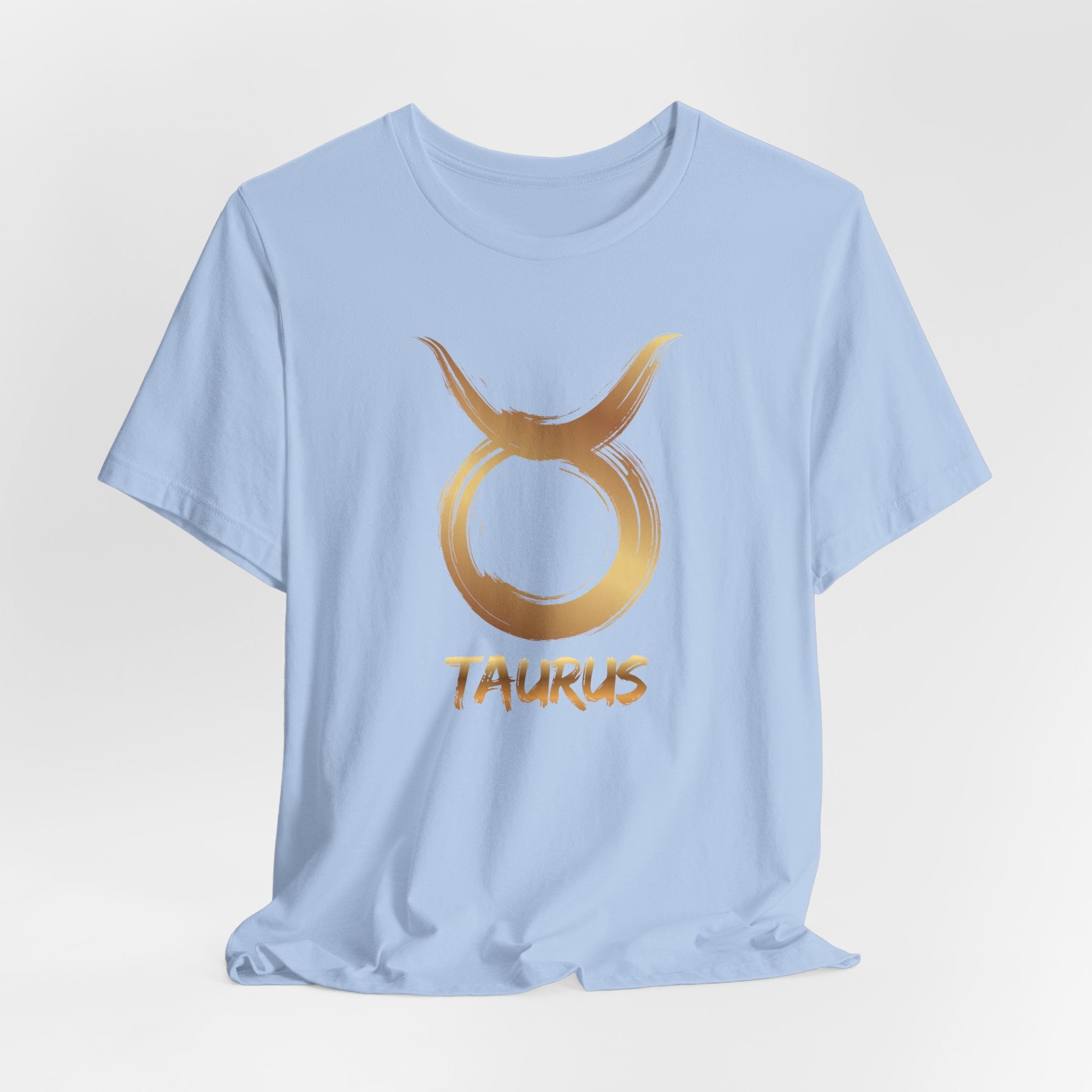 Light blue t-shirt with gold Taurus zodiac symbol on a light gray background