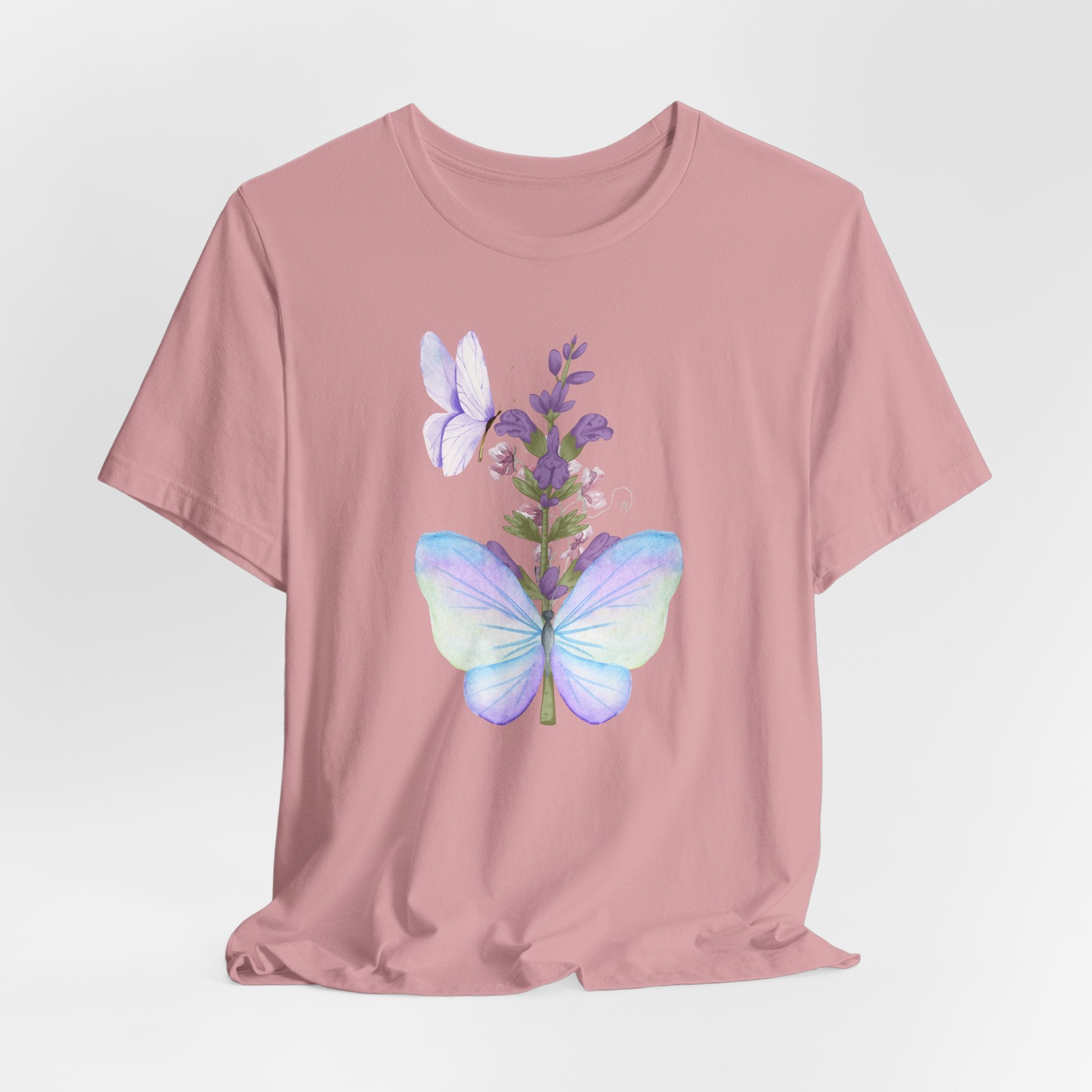 Pink t-shirt with a butterfly and flower design on a light gray background