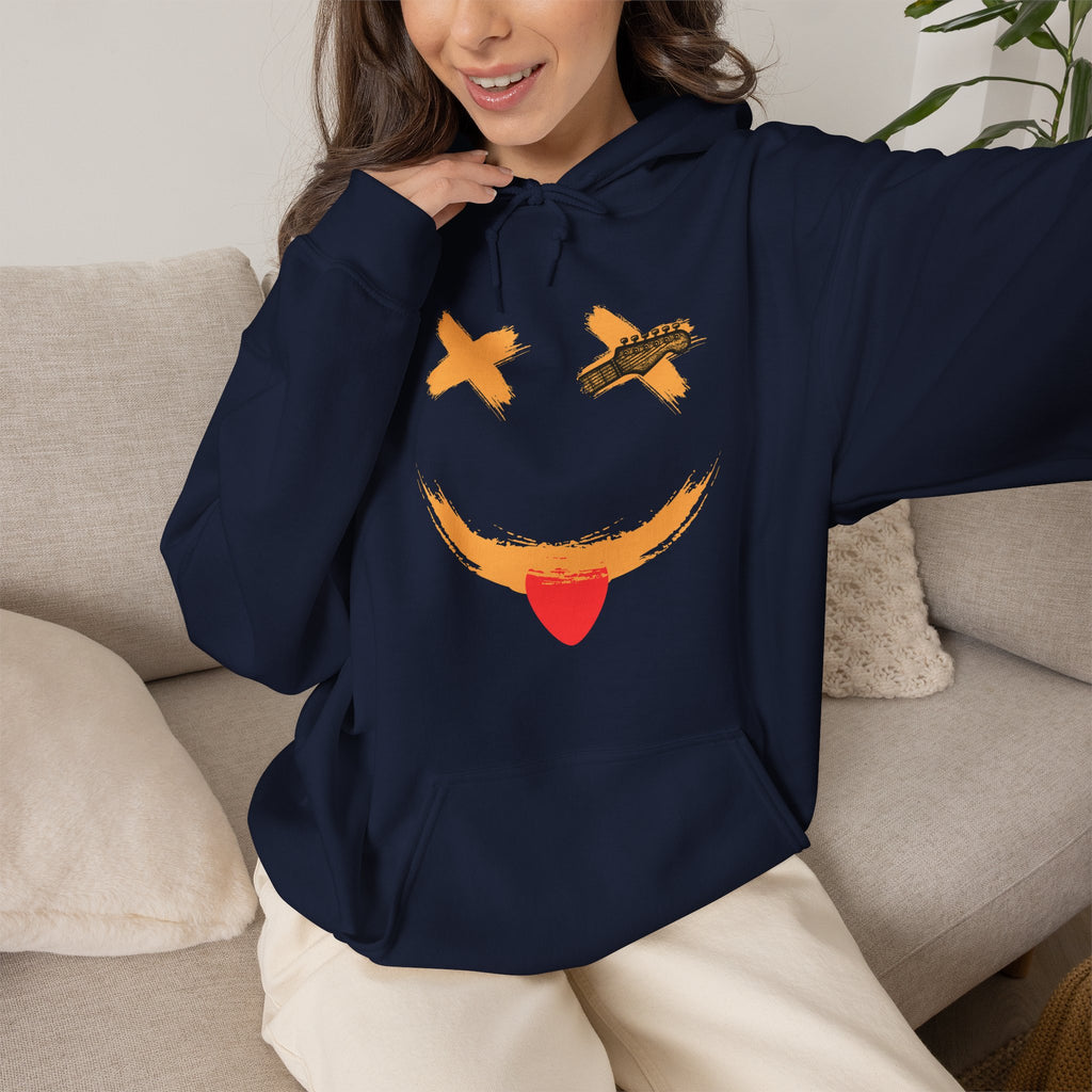 Person wearing a navy blue hoodie with a smiley face design, sitting on a couch.