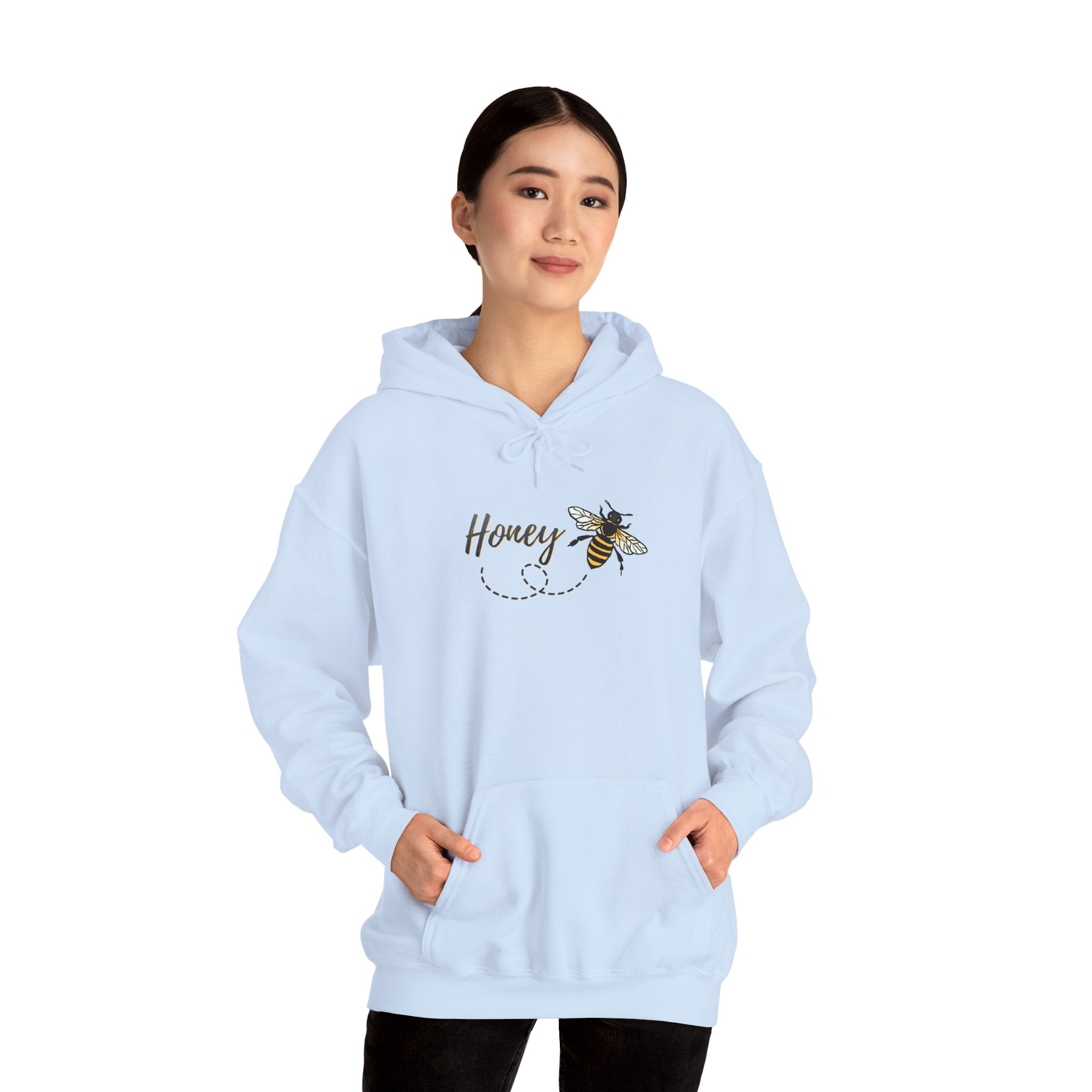 A woman wearing light blue hoodie with a bee and 'Honey' text design on a white background