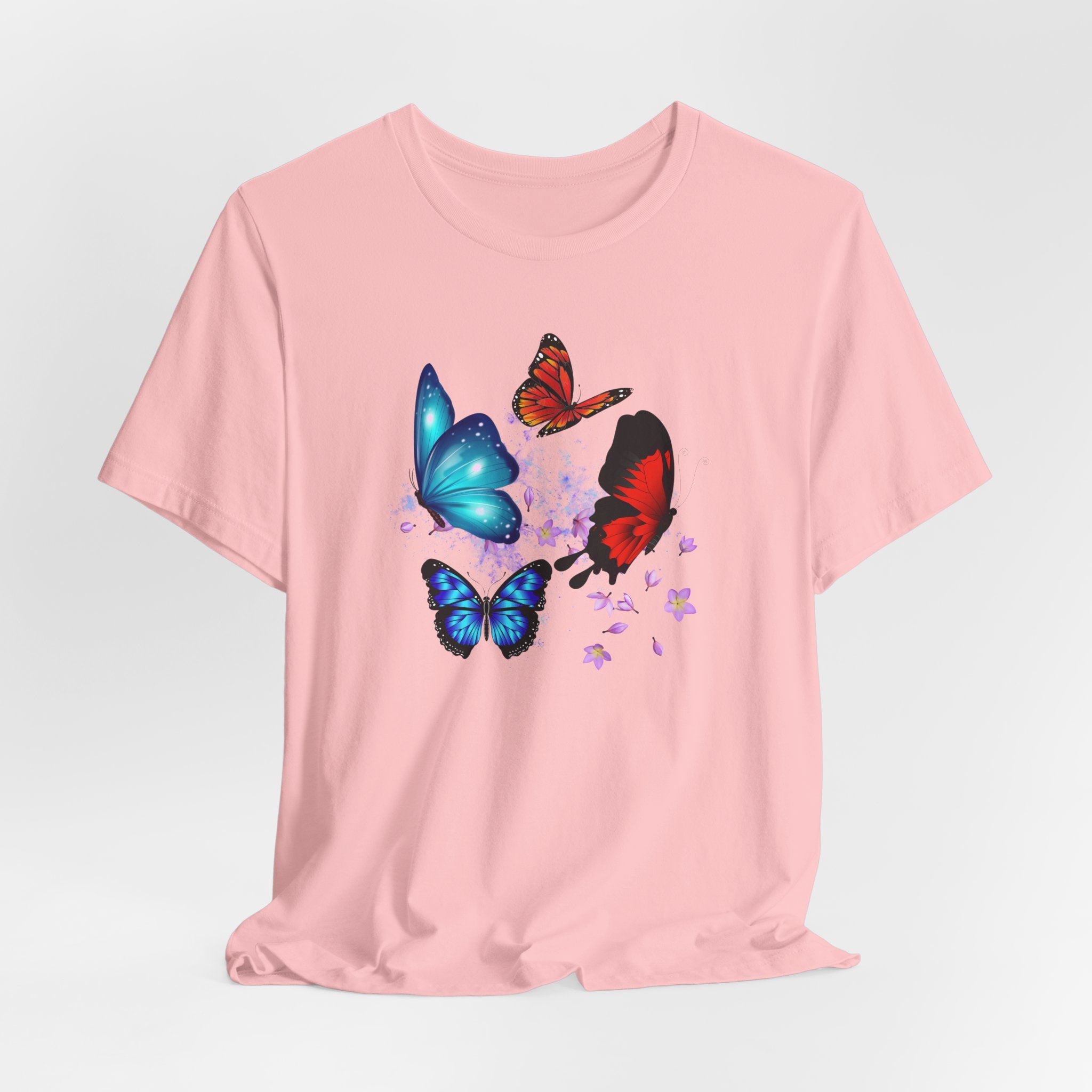 Pink t-shirt with colorful butterfly designs on a light gray background