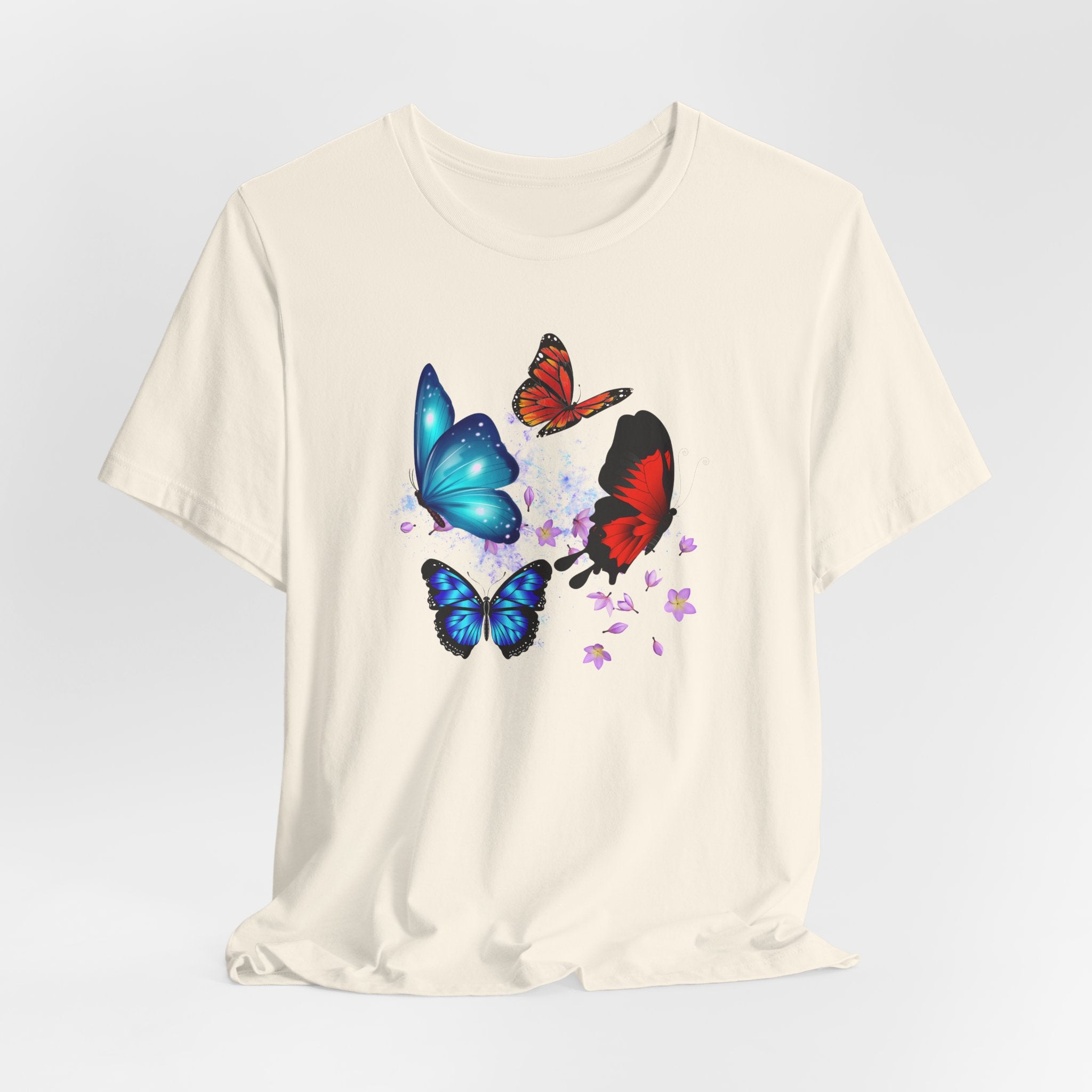 White t-shirt with colorful butterfly designs on a light gray background