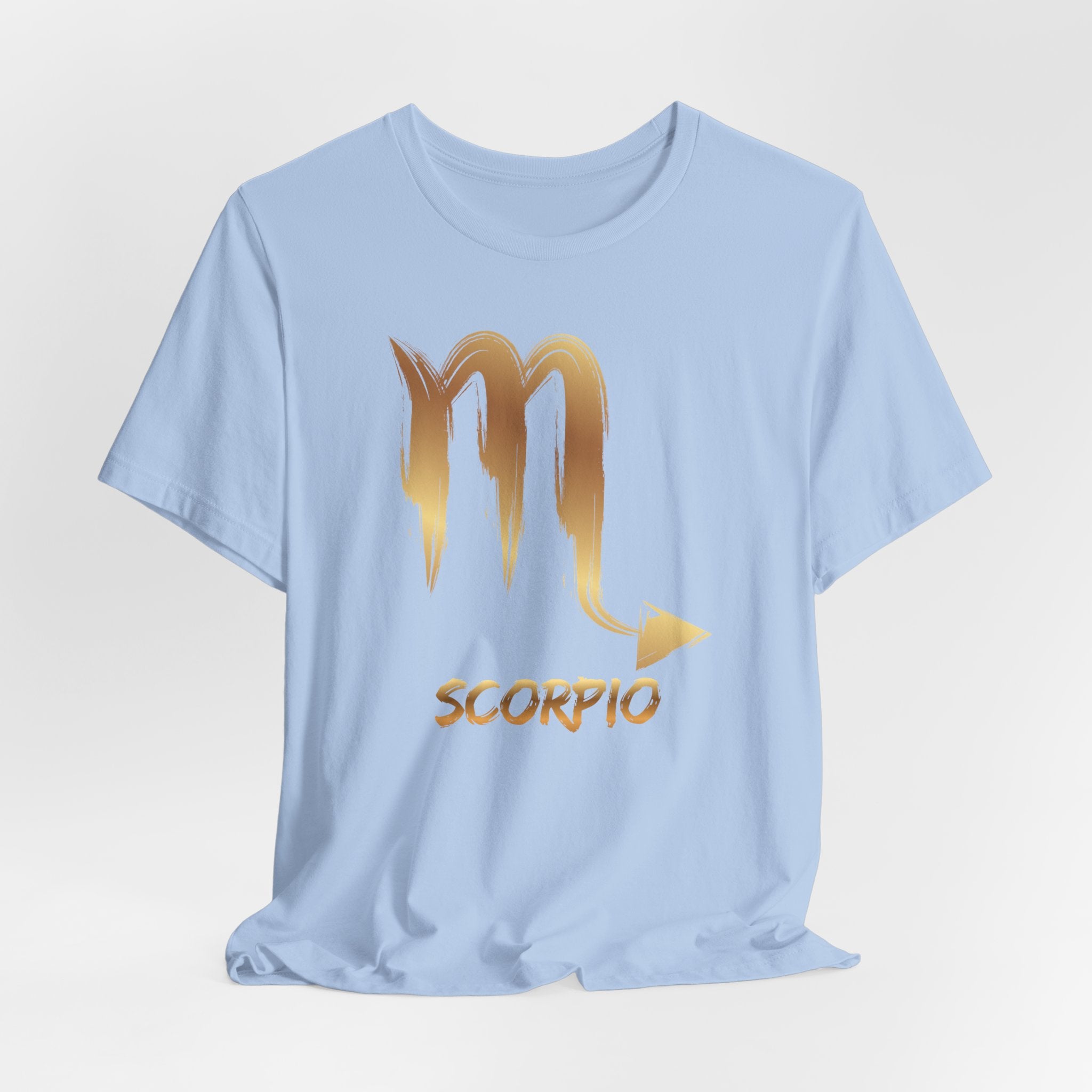 Light blue t-shirt with gold Scorpio zodiac symbol on a light gray background