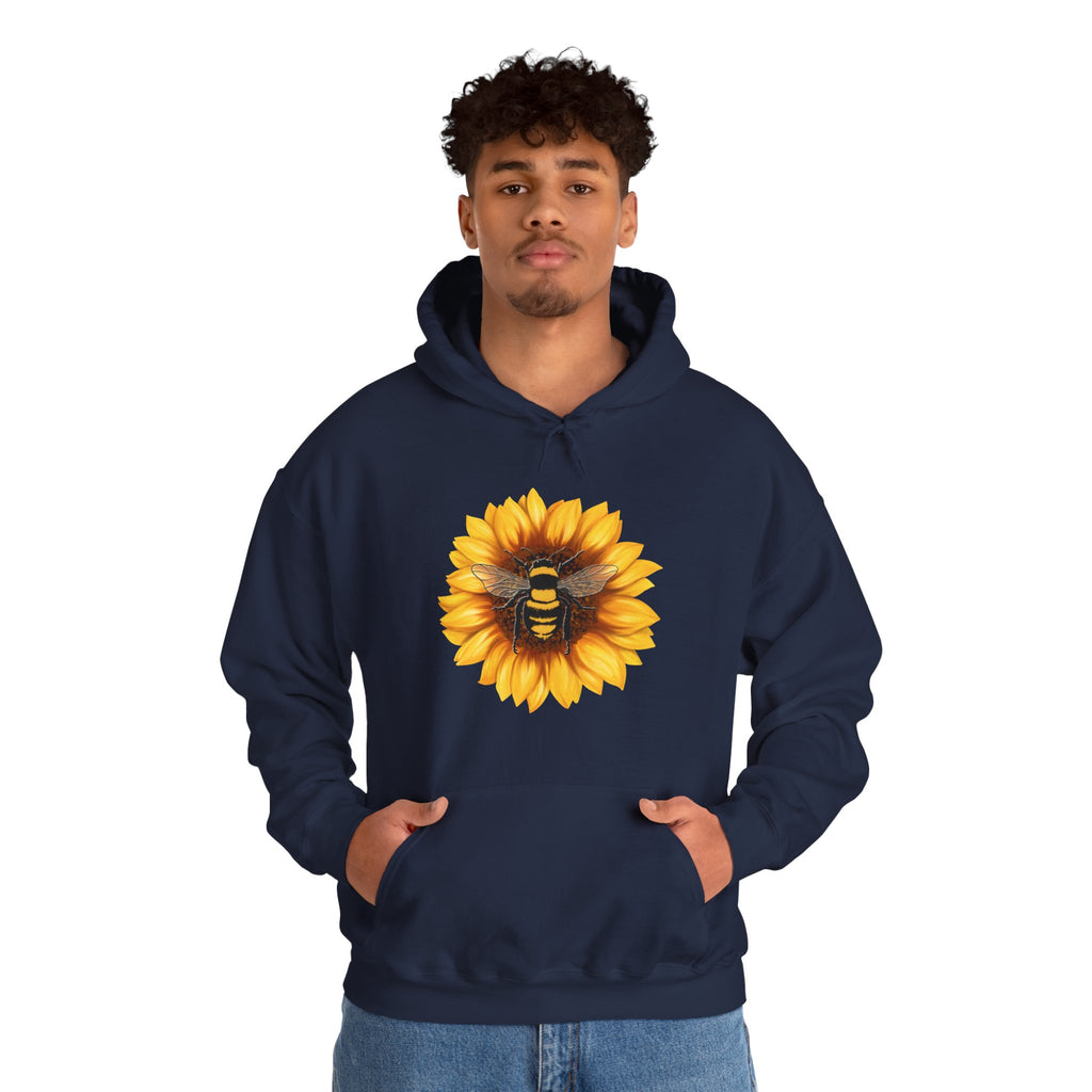 Person wearing a navy hoodie with a sunflower and bee design on a white background