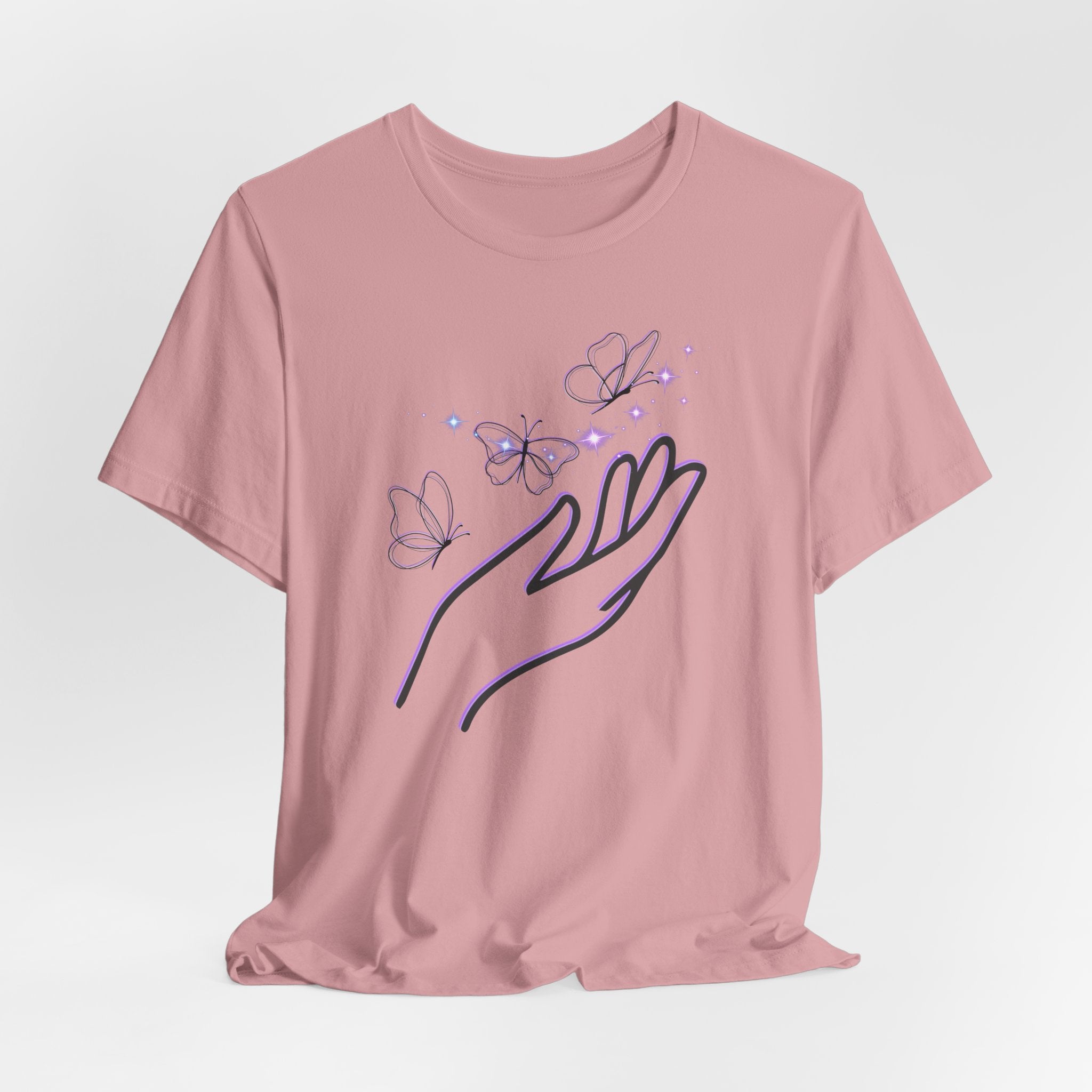 Pink t-shirt with a hand and butterfly design on a light gray background