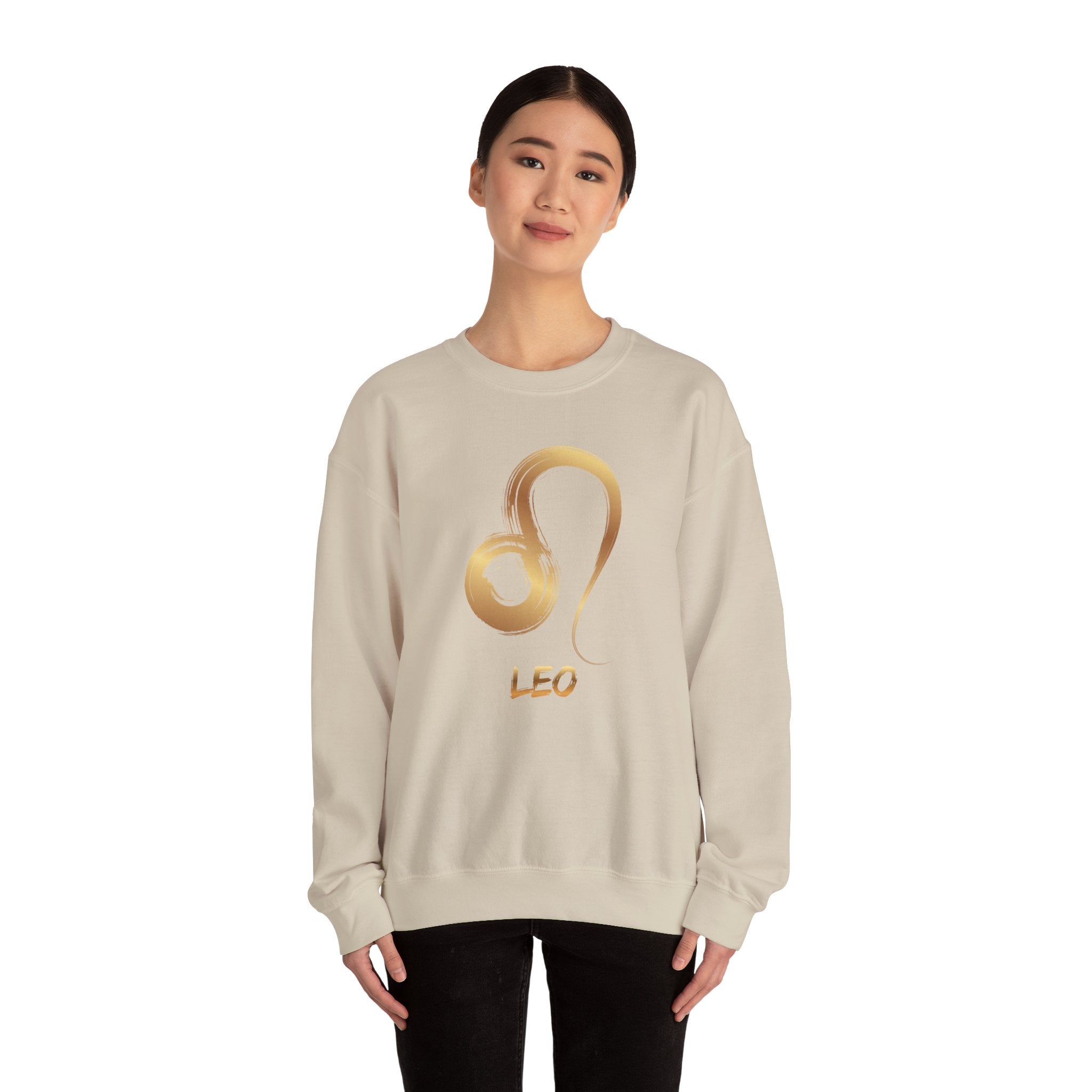 Person wearing a beige sweatshirt with a gold 'Leo' design on a white background