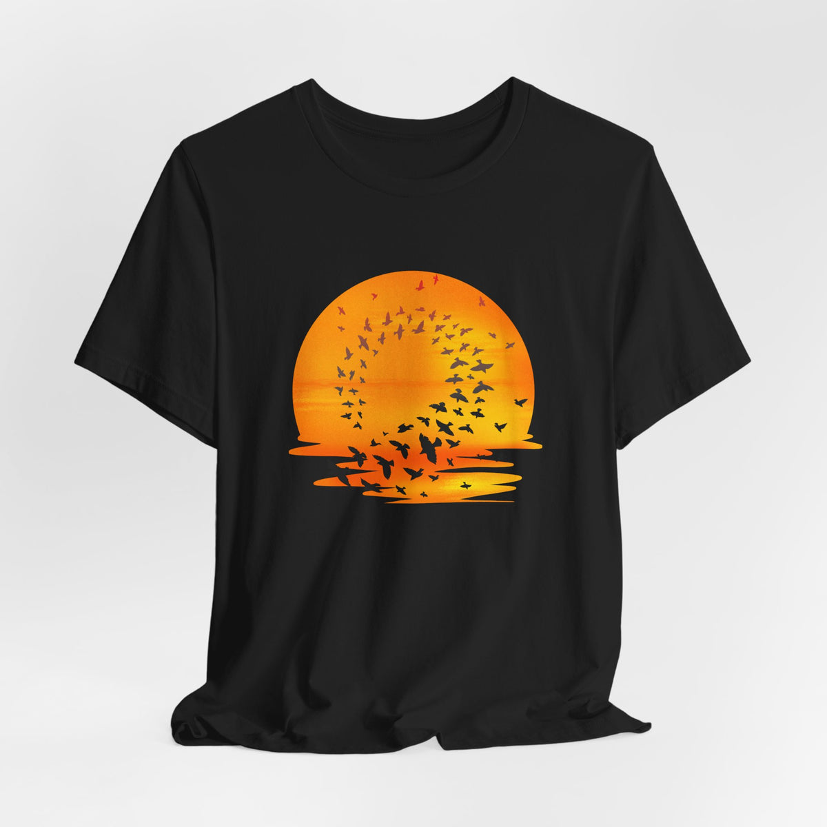 Black t-shirt with an orange sunset and bird design on a white background