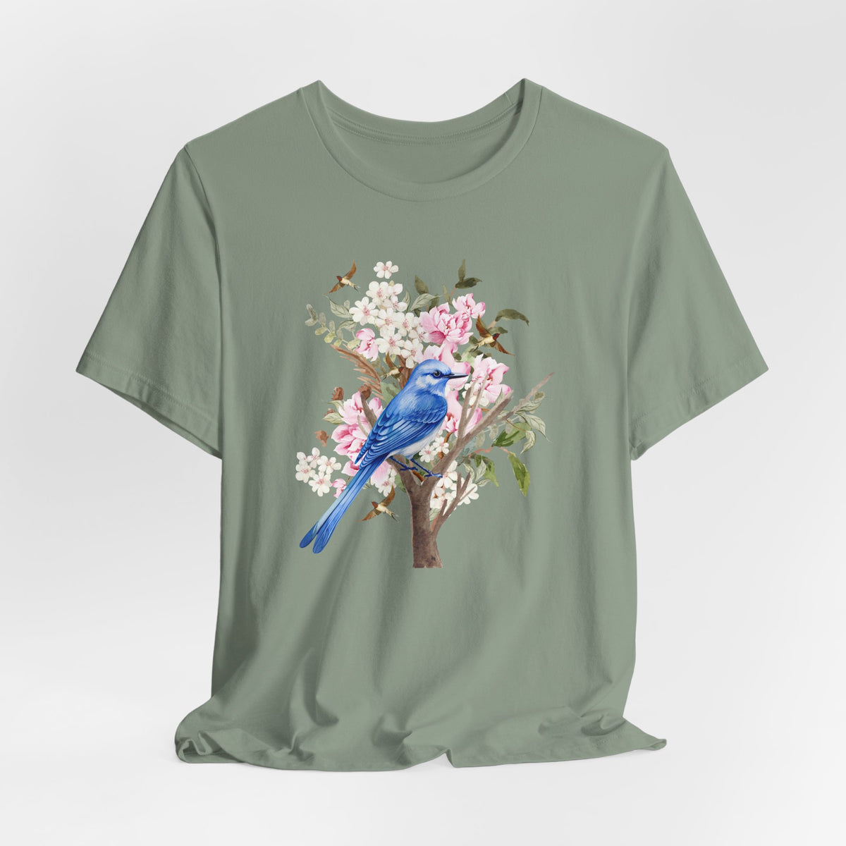 Green t-shirt with a blue bird and floral design on a light gray background