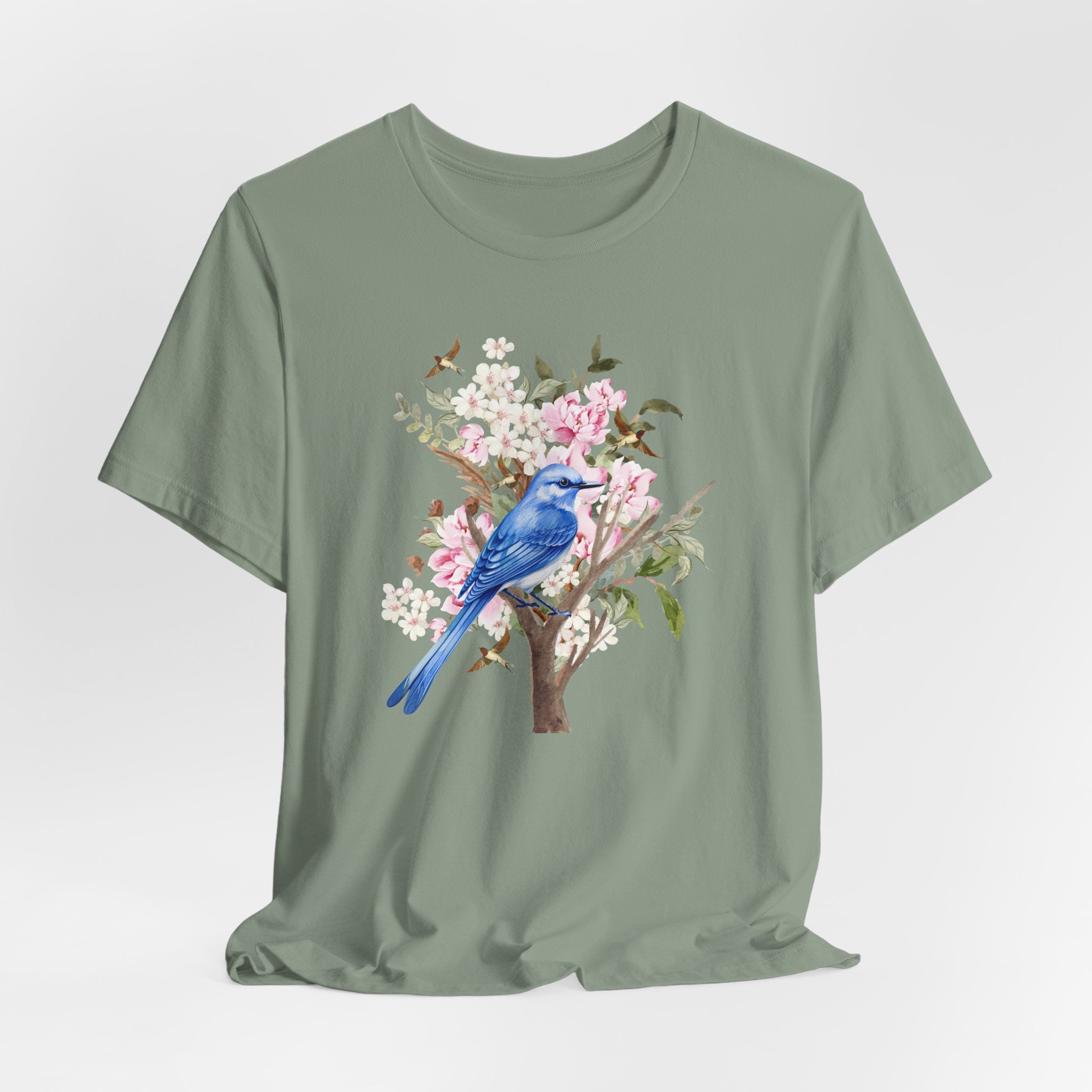 Green t-shirt with a blue bird and floral design on a light gray background