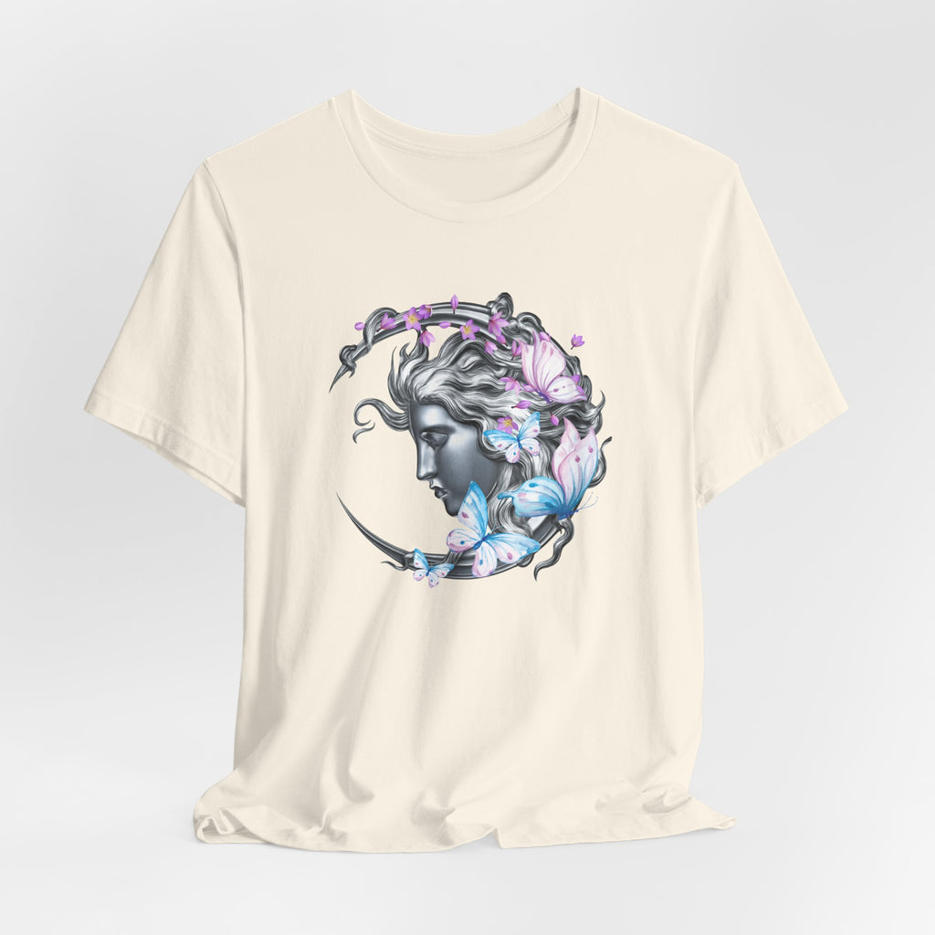 Beige t-shirt with a graphic design of a woman's face surrounded by butterflies on a light gray background