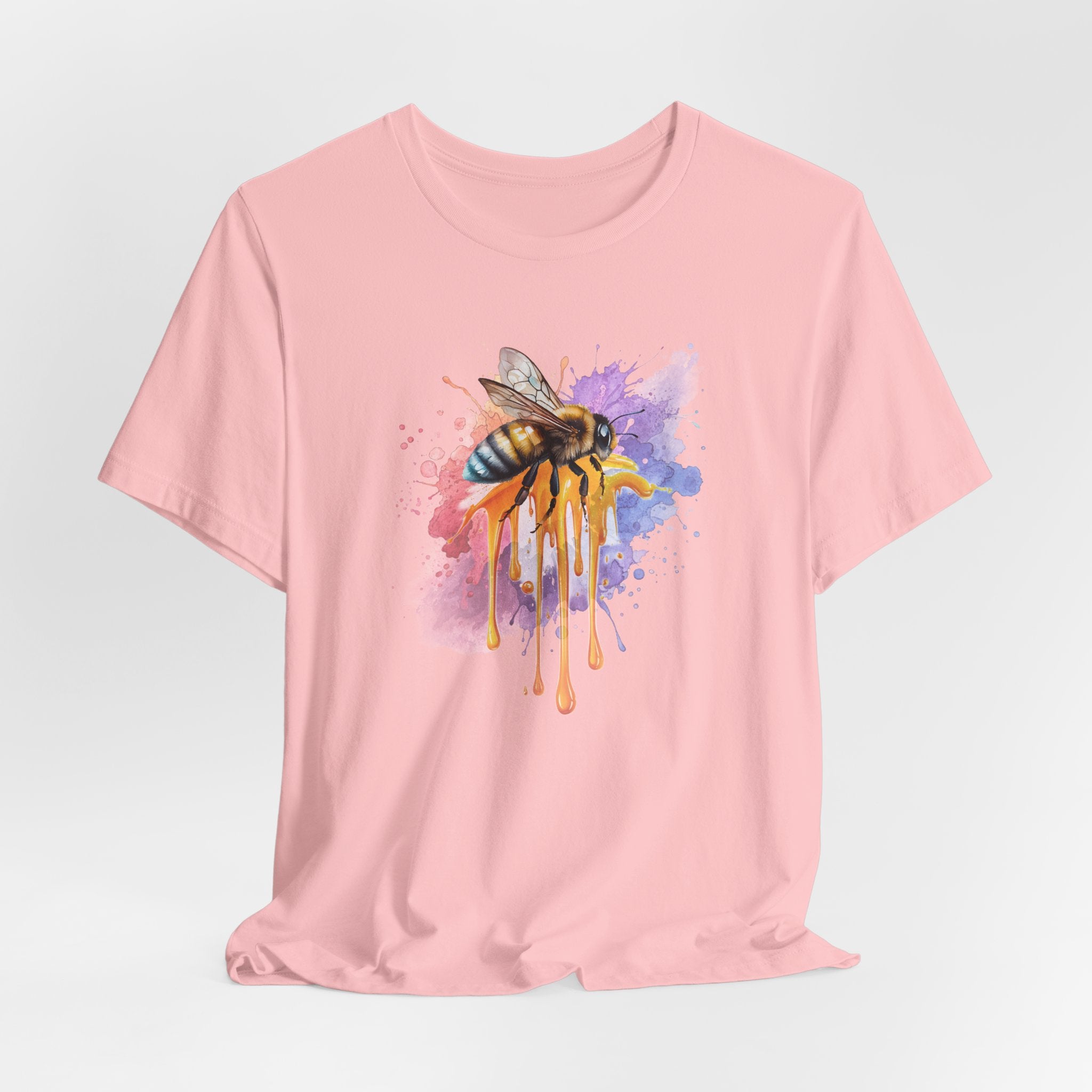 Pink t-shirt with a colorful bee design on a light gray background