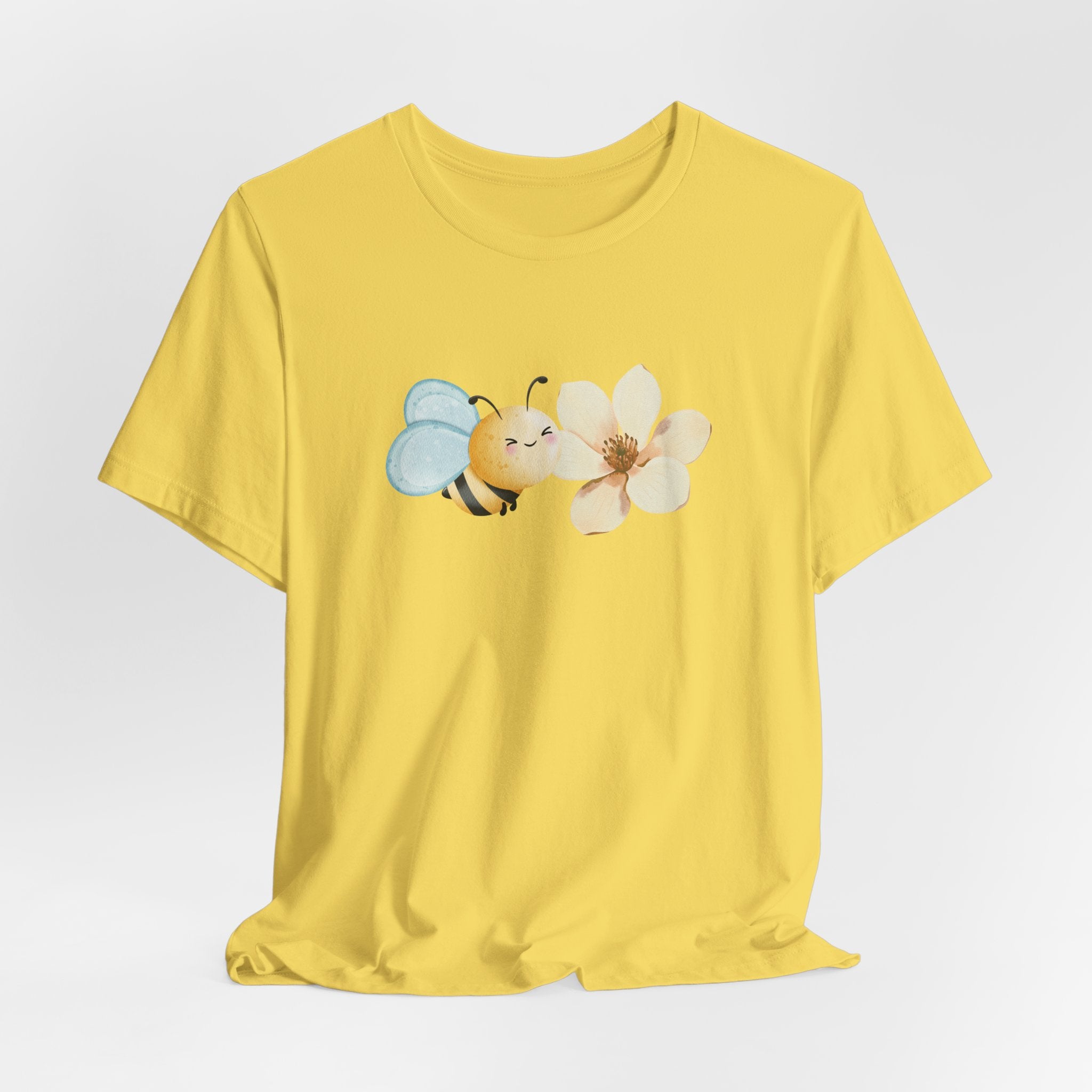 Yellow t-shirt with a bee and flower graphic on a light gray background