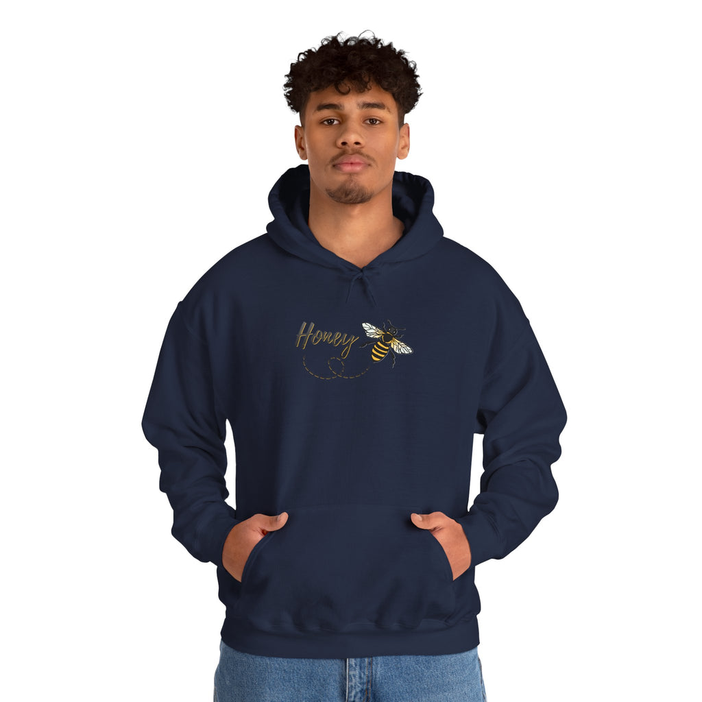 Person wearing a navy hoodie with a bee and 'Honey' design on a white background