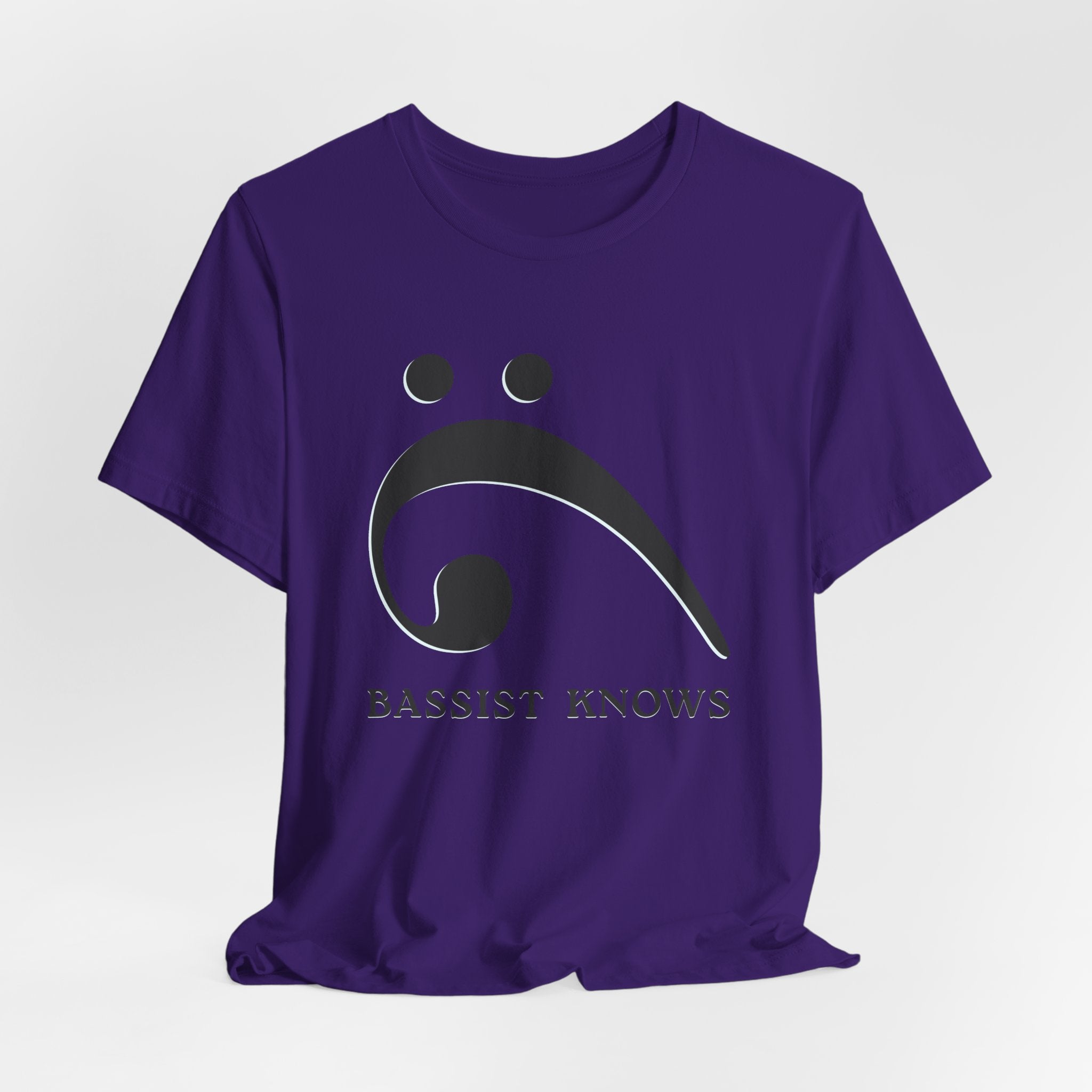 Purple t-shirt with black bass clef and 'Bassist Knows' text on a light gray background
