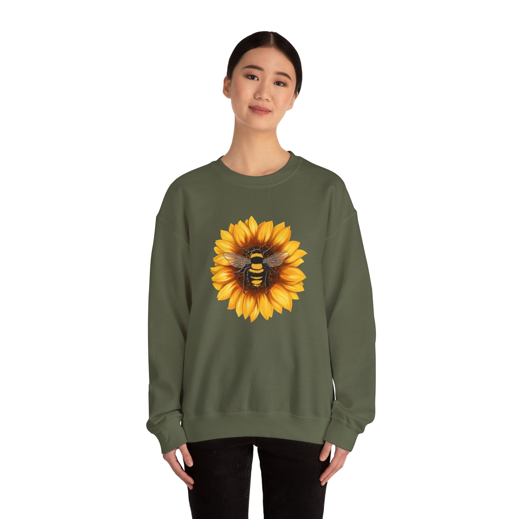 Person wearing a green sweatshirt with a sunflower and bee design on a white background