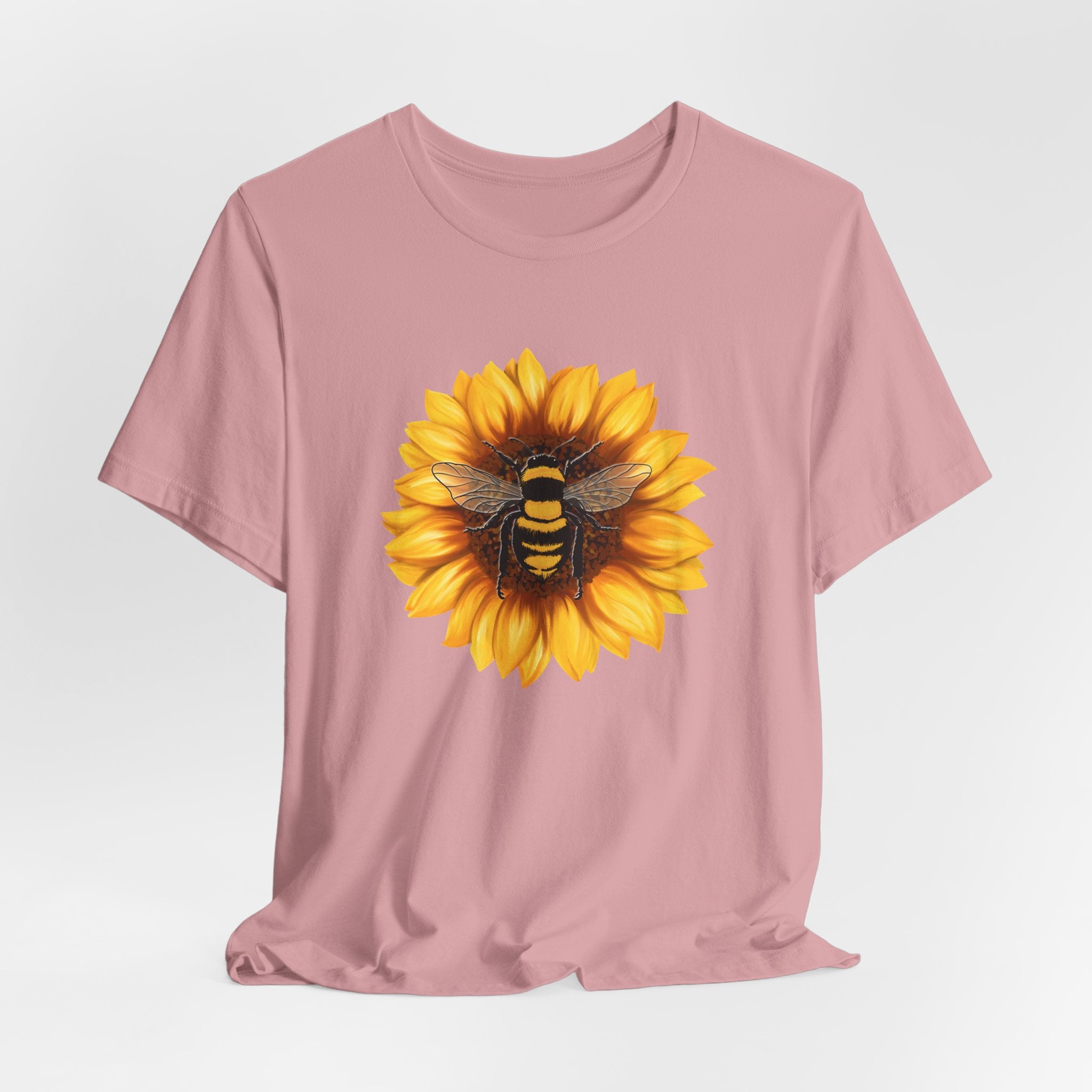 Pink t-shirt with a sunflower and bee design on a white background