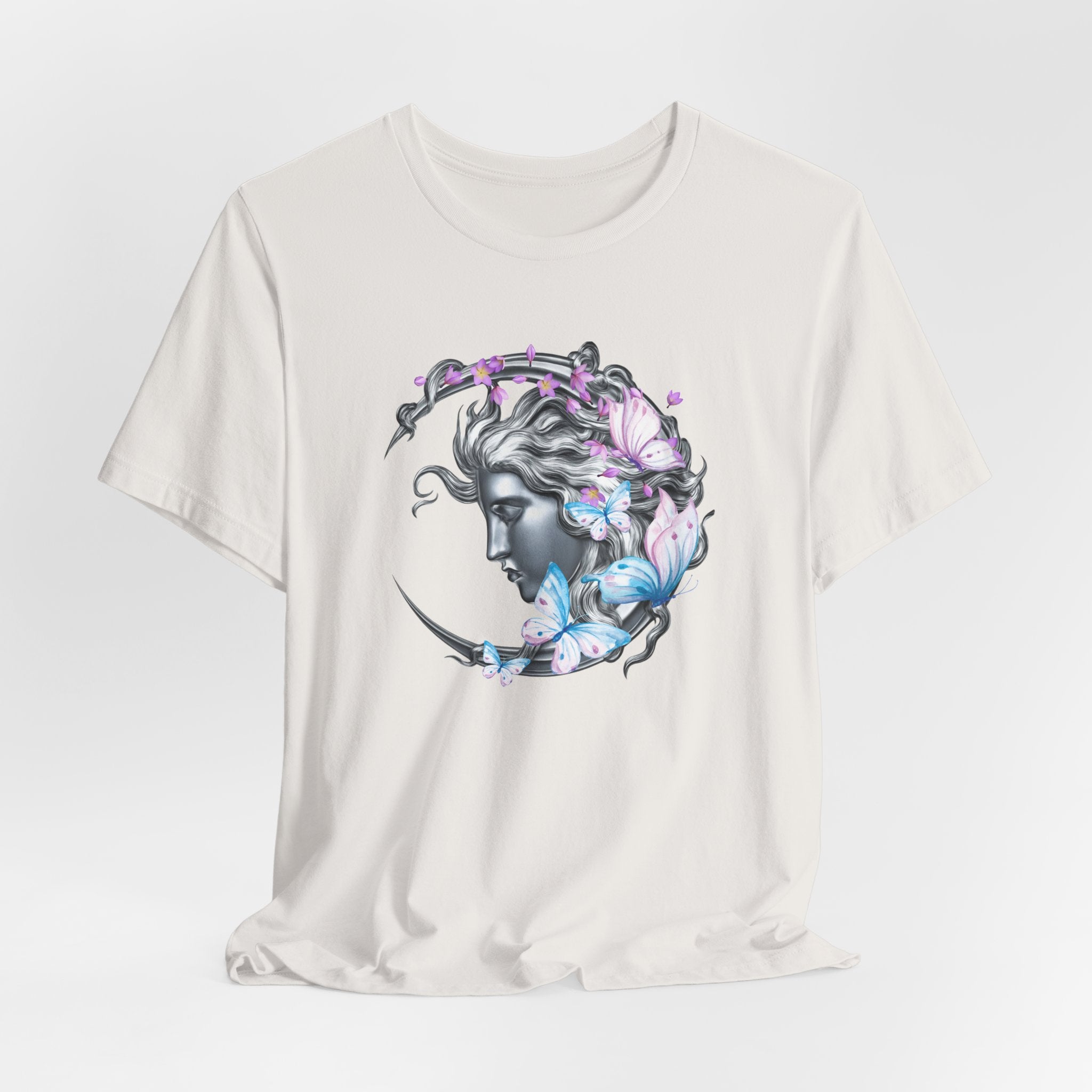 White t-shirt with a graphic design of a woman's face surrounded by butterflies and flowers on a light gray background.