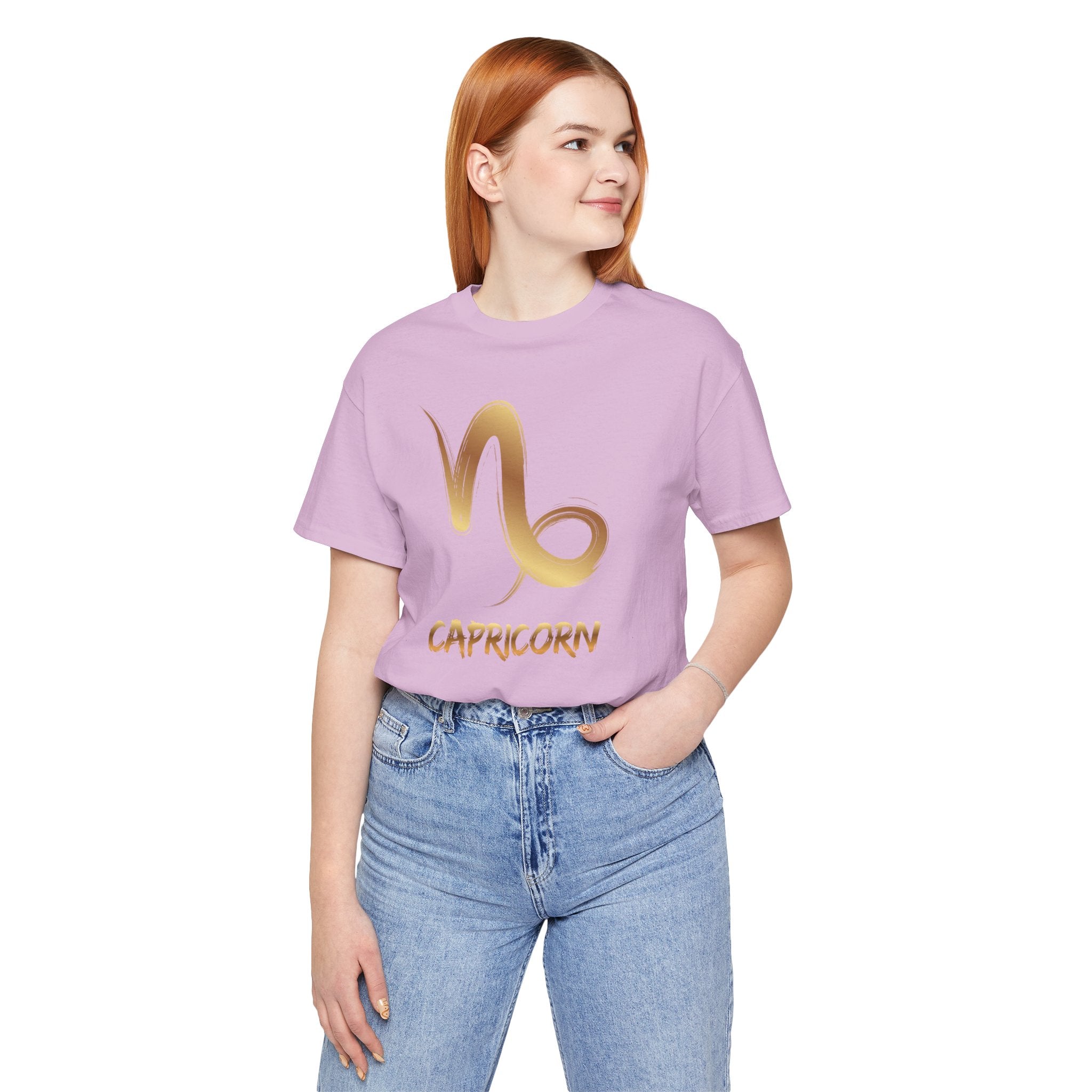 Person wearing a purple t-shirt with a gold Capricorn symbol design on a white background
