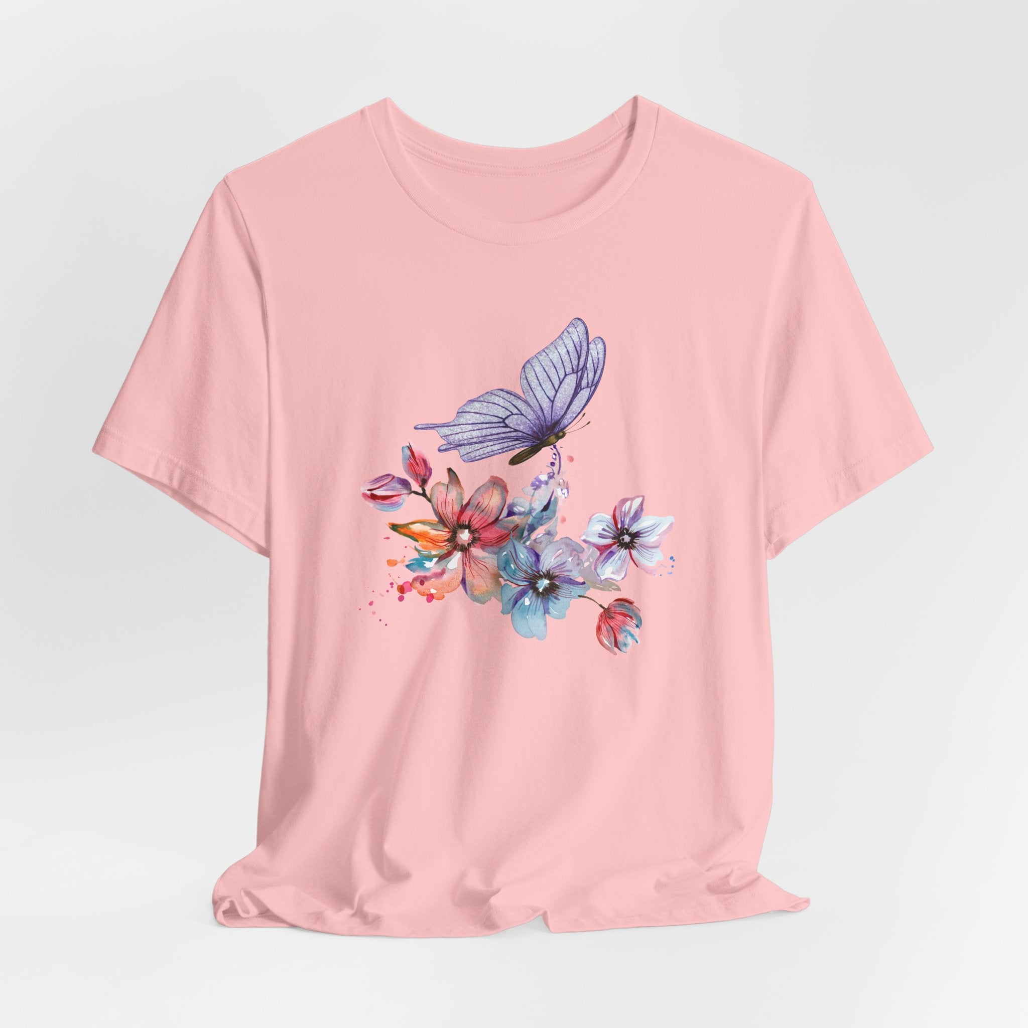Pink t-shirt with a colorful butterfly and floral design on a light gray background