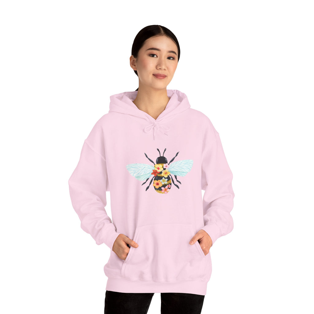 Person wearing a pink hoodie with a bee design on a white background