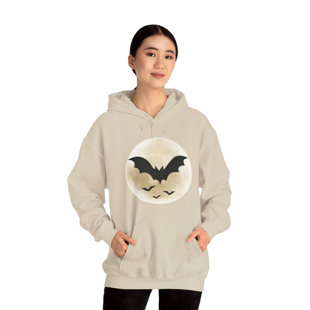Person wearing a beige hoodie with a bat design on a white background