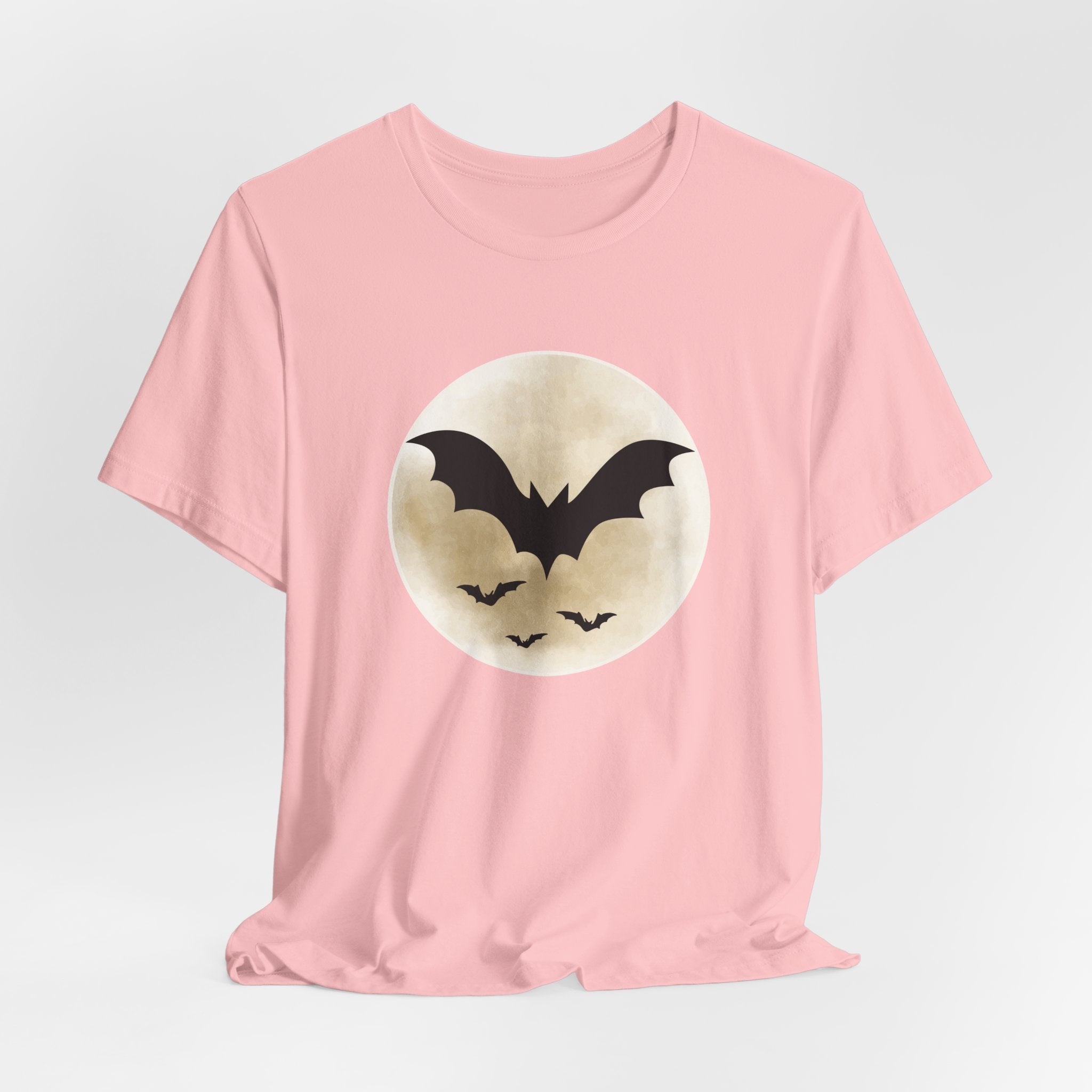 Pink t-shirt with full moon and bats design on a light gray background