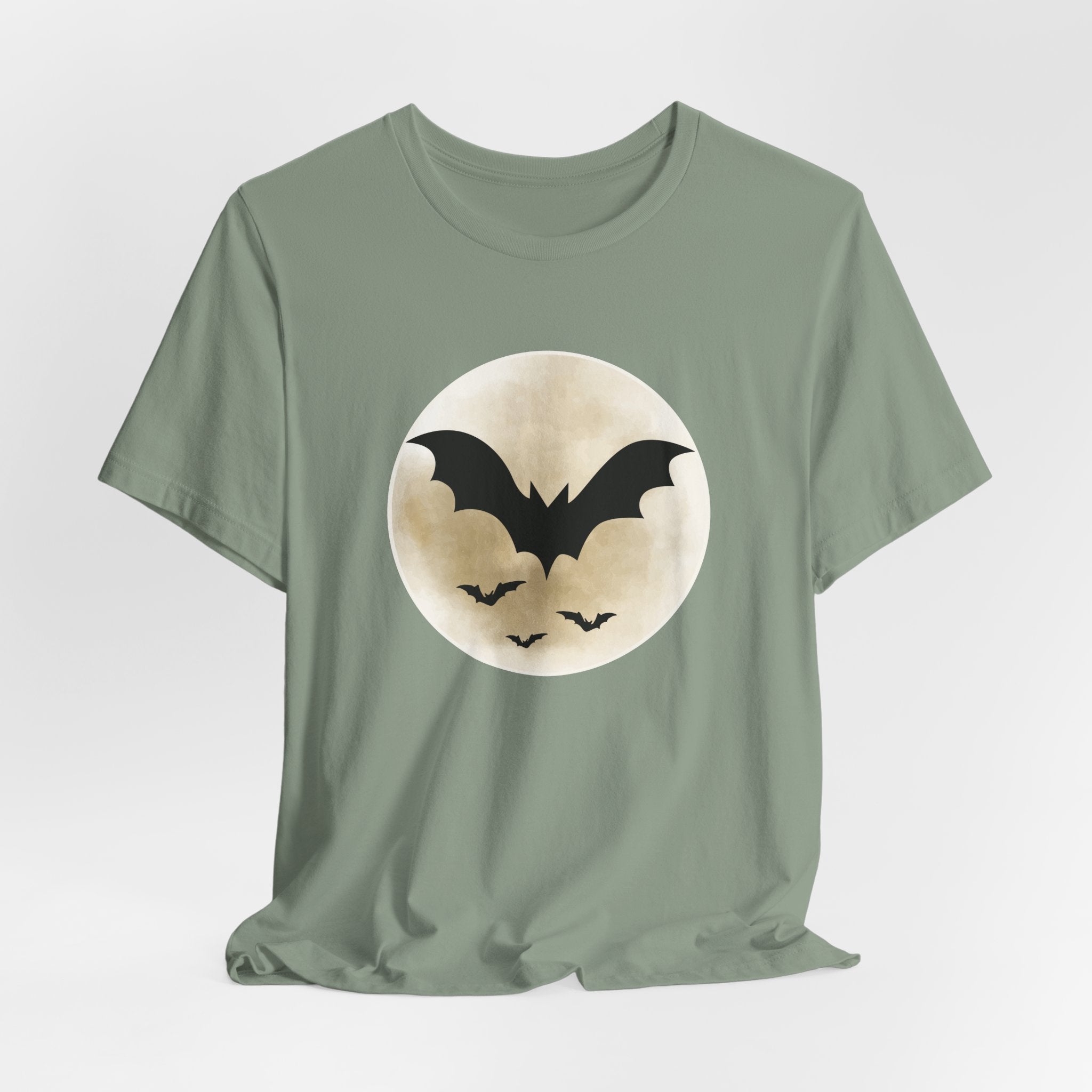 Sage green t-shirt with full moon and bats design on a light gray background