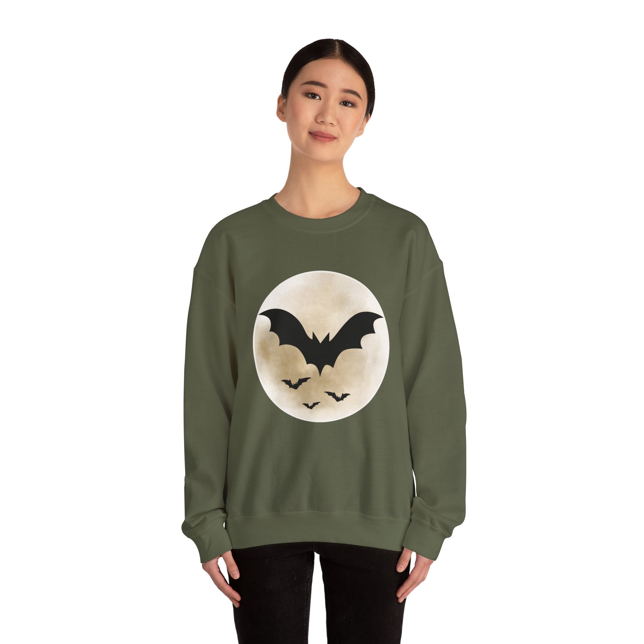 Person wearing a green sweatshirt with a bat and moon design on a white background