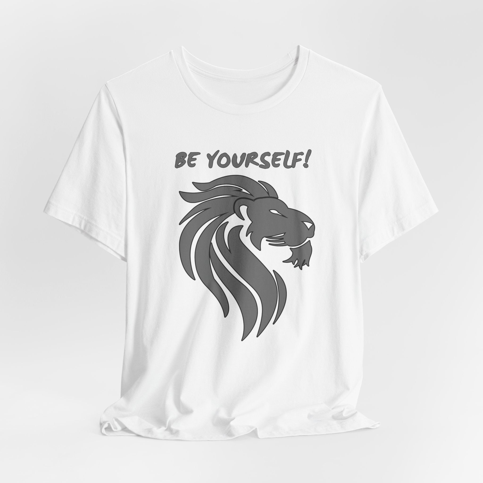 White t-shirt with a lion graphic and 'Be Yourself!' text on a light gray background