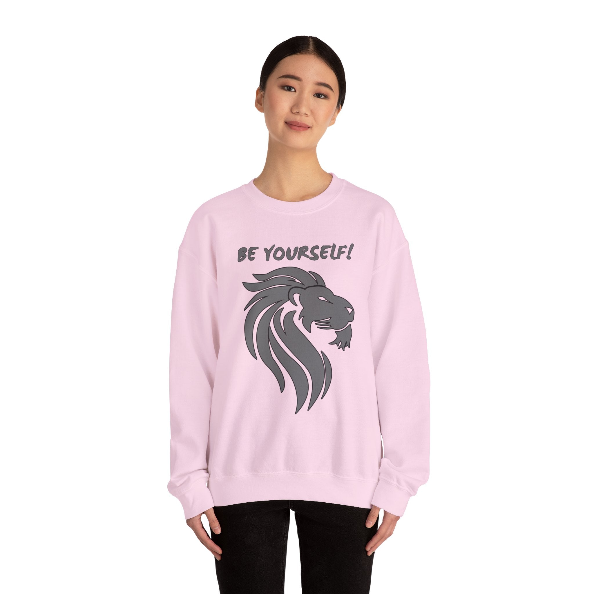 Person wearing a pink sweatshirt with a lion graphic and 'Be Yourself!' text on a white background