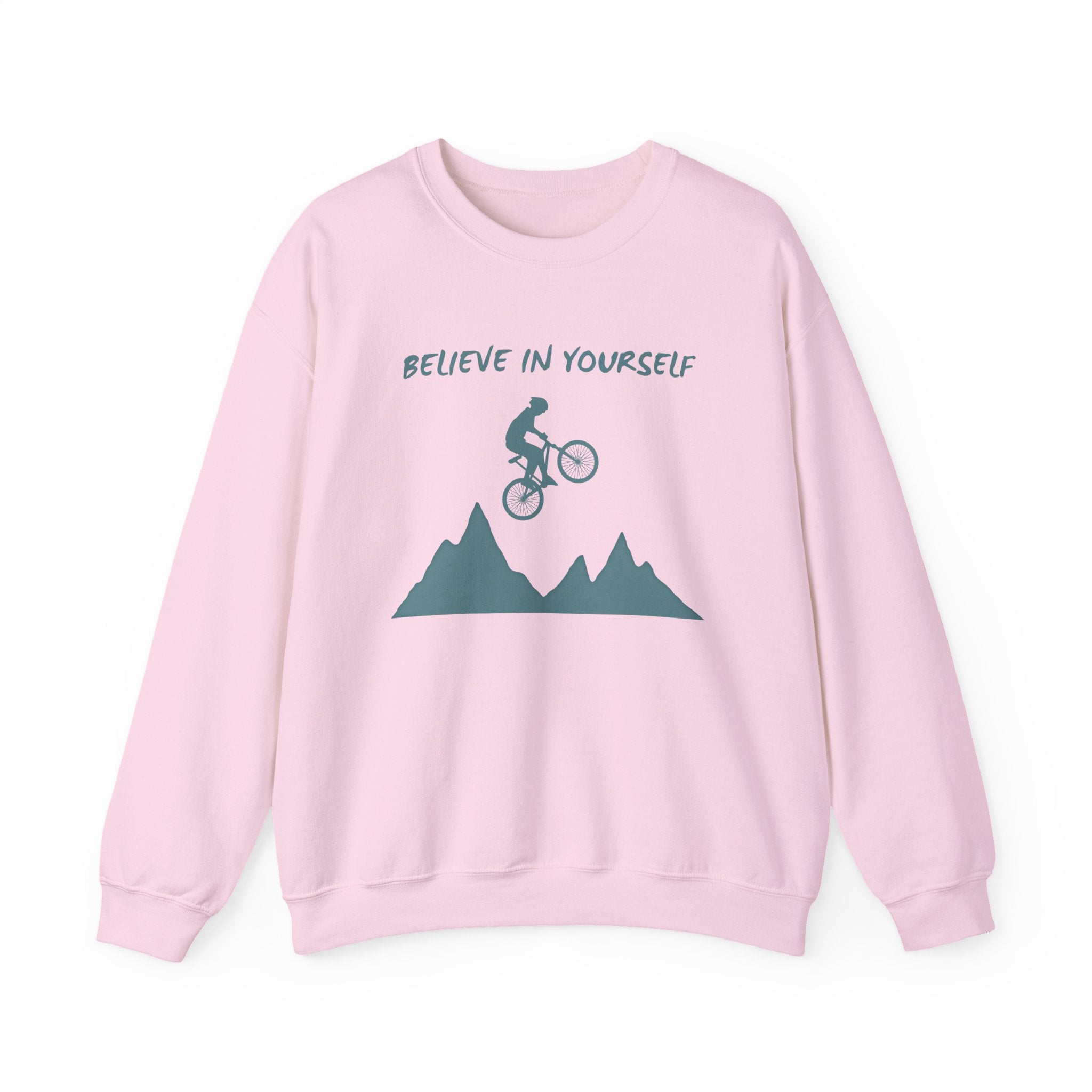 Light pink sweatshirt with mountain and bike graphic and 'Believe in Yourself' text on a white background