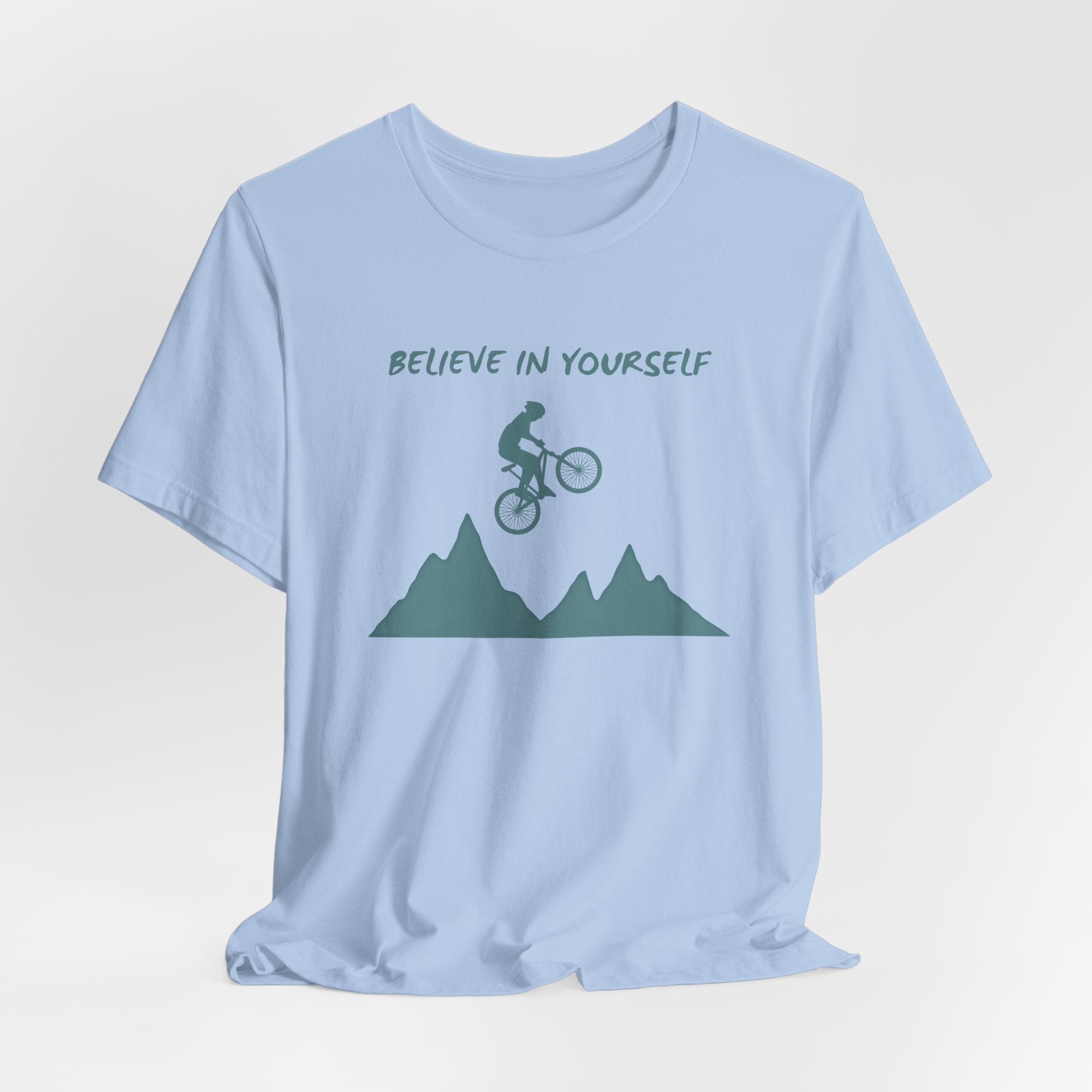 Baby light blue t-shirt with mountain and bicycle graphic and 'Believe in Yourself' text on a light gray background
