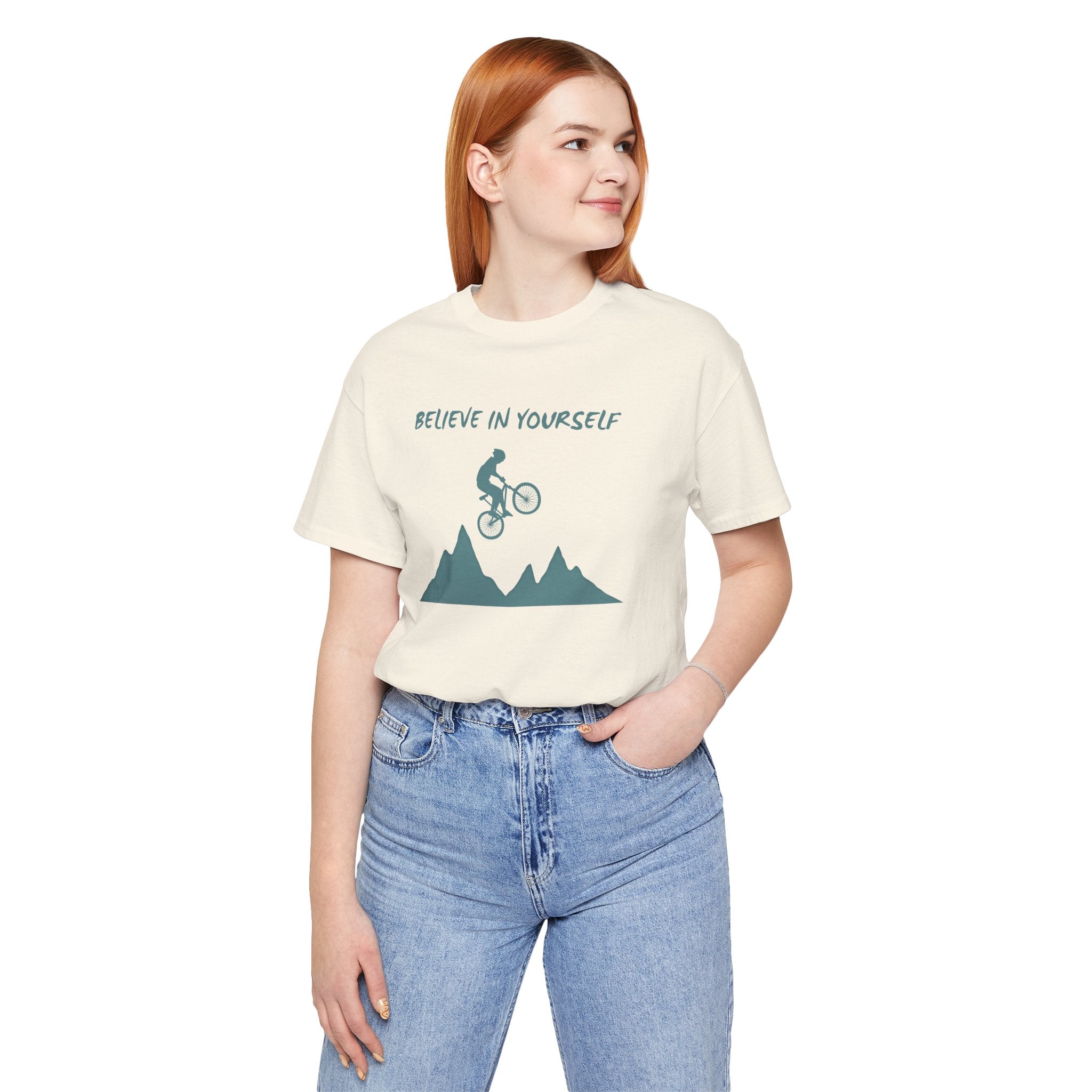 Person wearing a t-shirt with a mountain bike graphic and 'Believe in Yourself' text on a white background