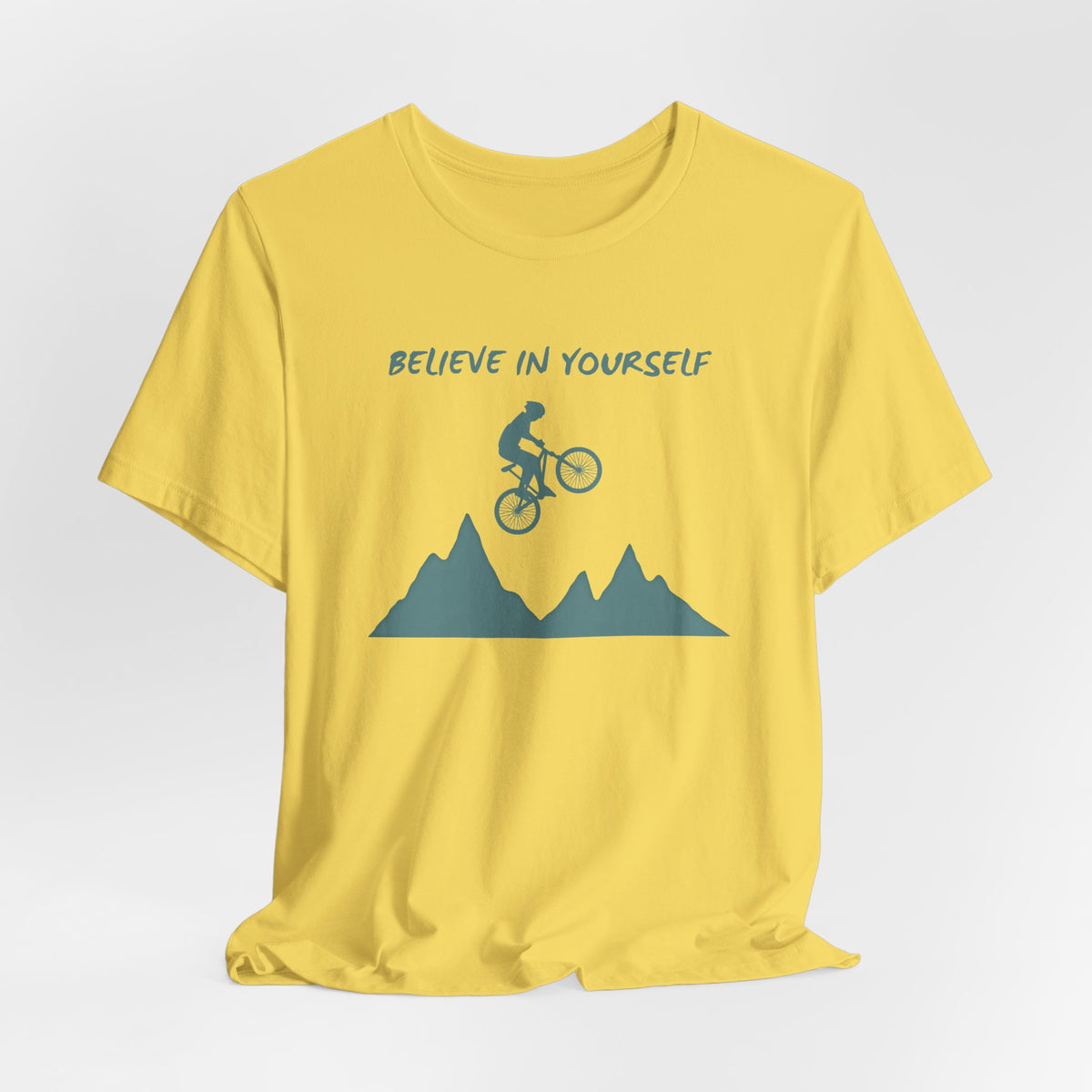 Yellow t-shirt with mountain bike graphic and 'Believe in Yourself' text on a white background