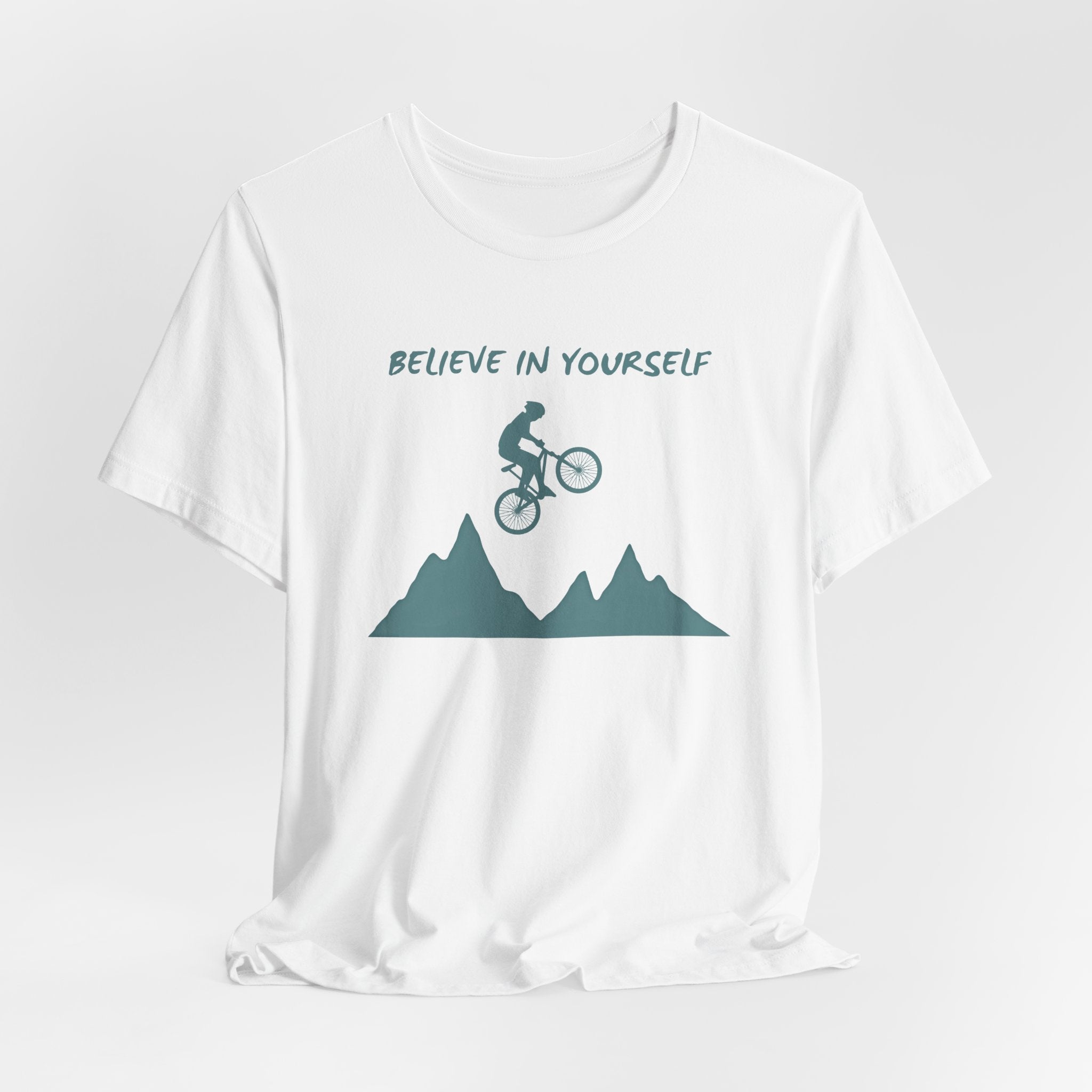 White t-shirt with mountain bike graphic and 'Believe in Yourself' text on a white background