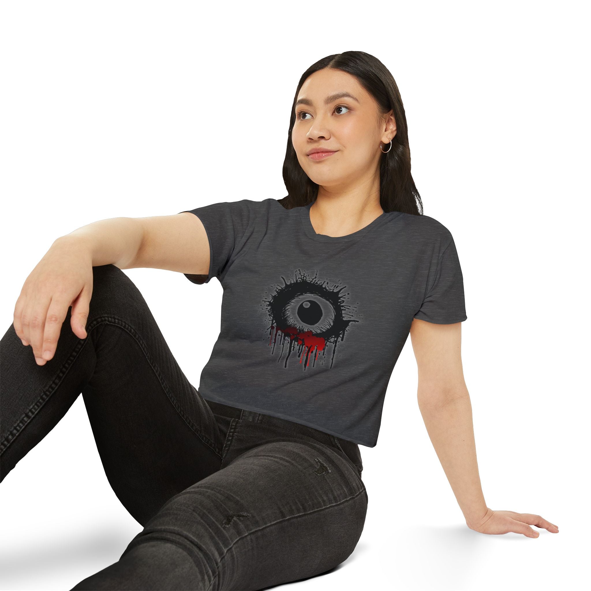 Woman wearing a dark gray t-shirt with a unique design, sitting on a white background