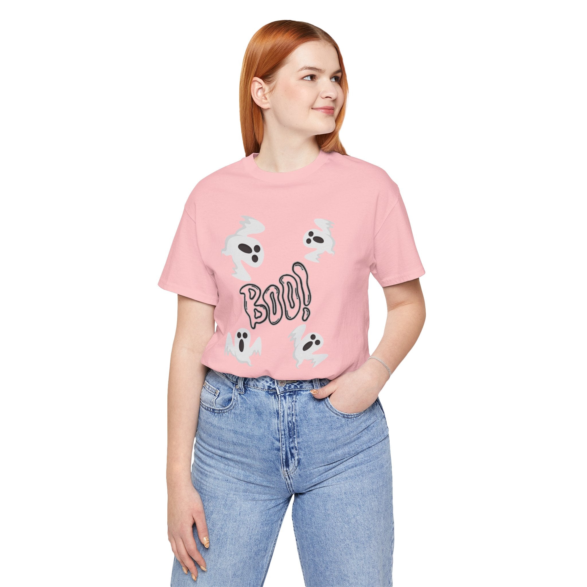 Person wearing a pink t-shirt with graphics and text, standing against a white background