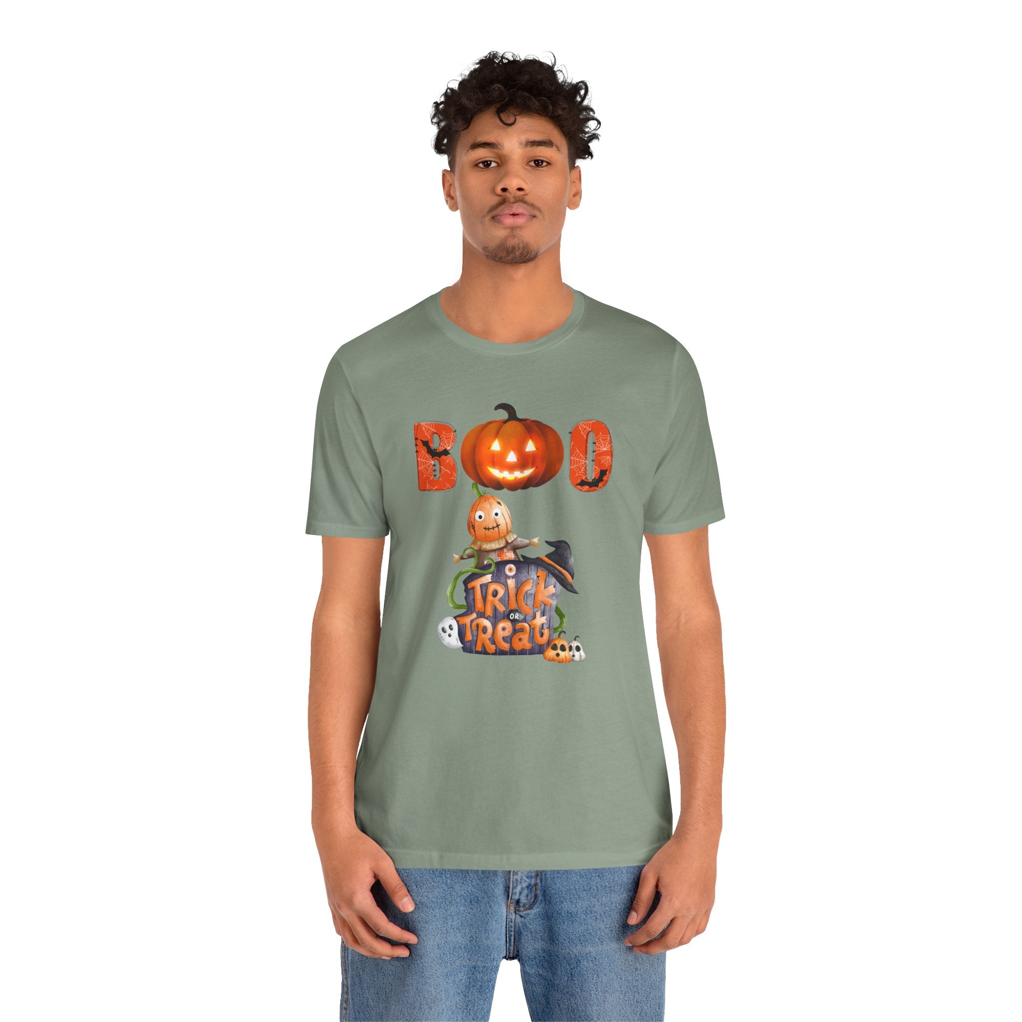 Person wearing a green t-shirt with a Halloween design featuring a pumpkin and text.