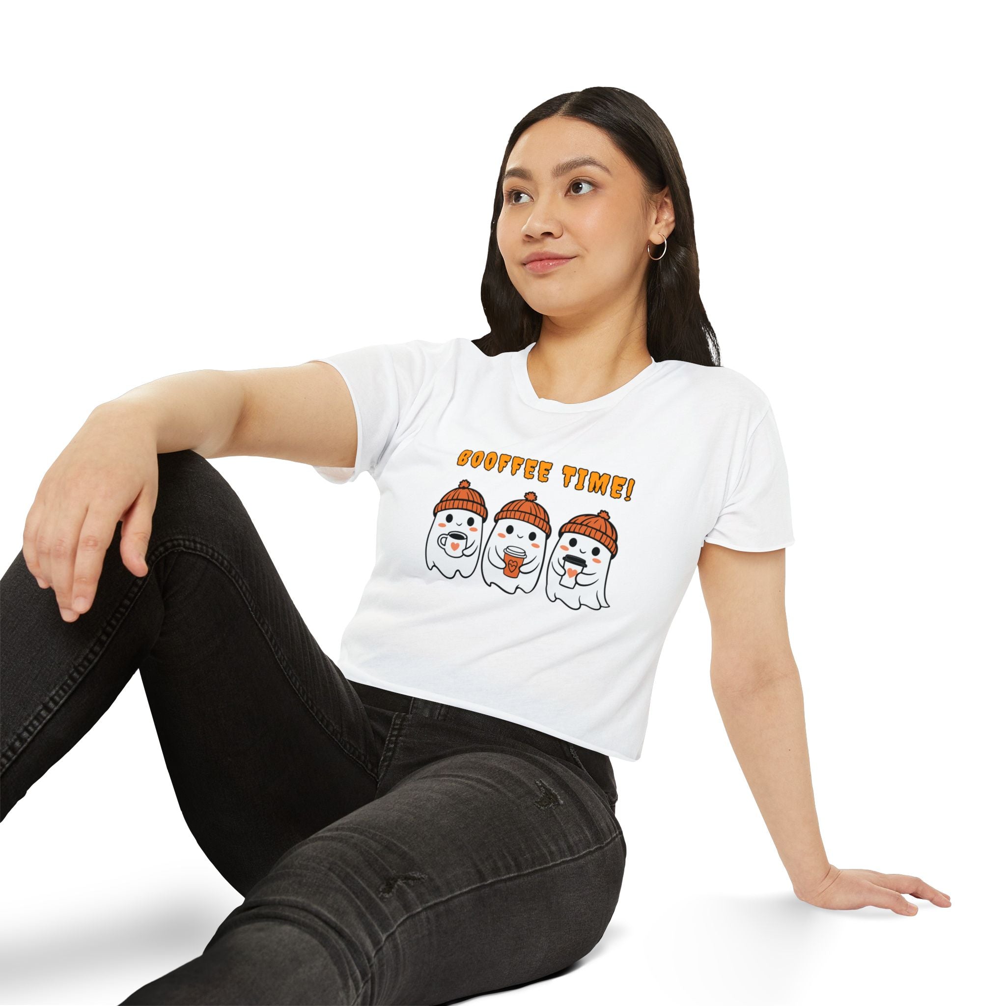 Woman wearing a white t-shirt with cartoon characters and text, sitting on a white background