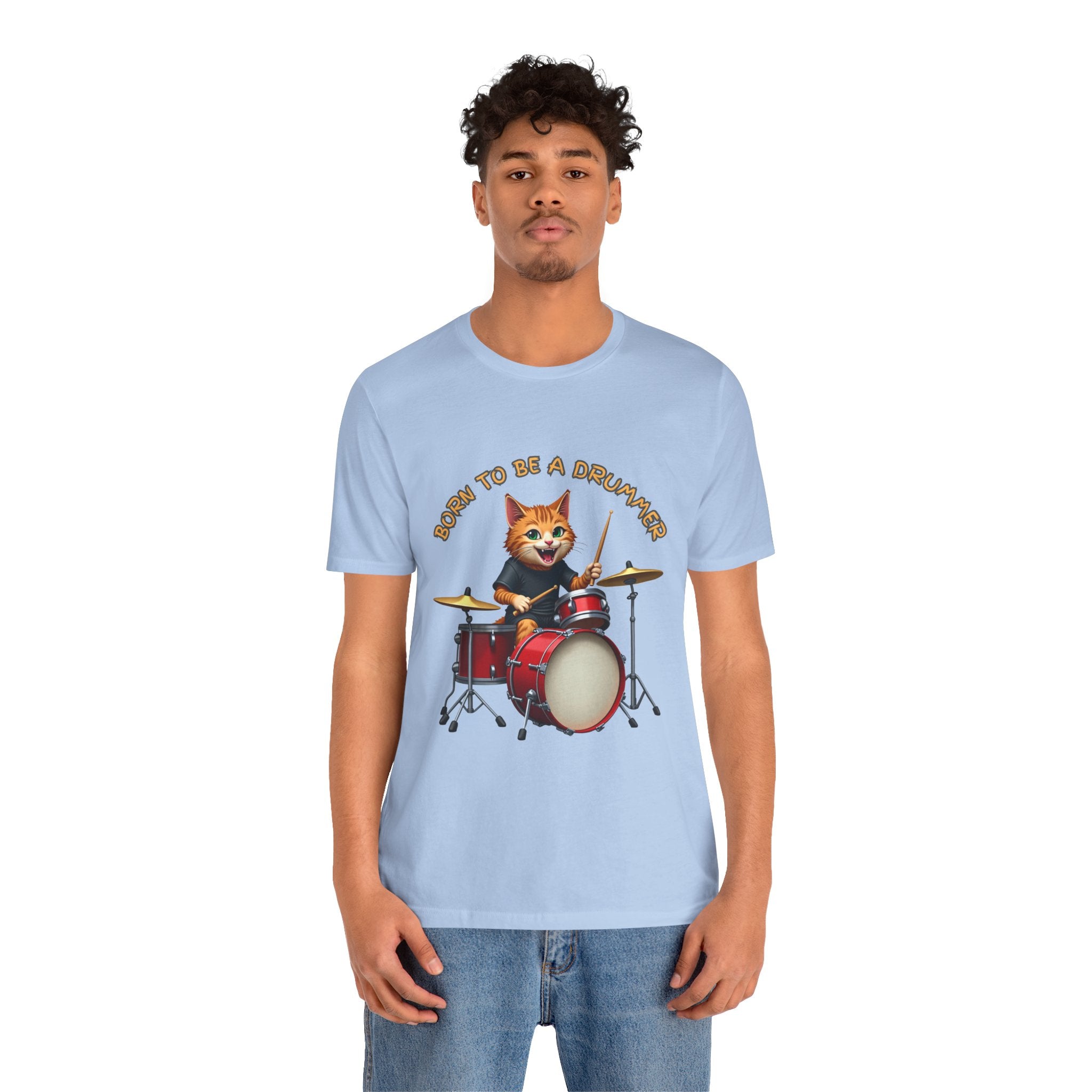 Person wearing a light blue t-shirt with a cat playing drums graphic and text.