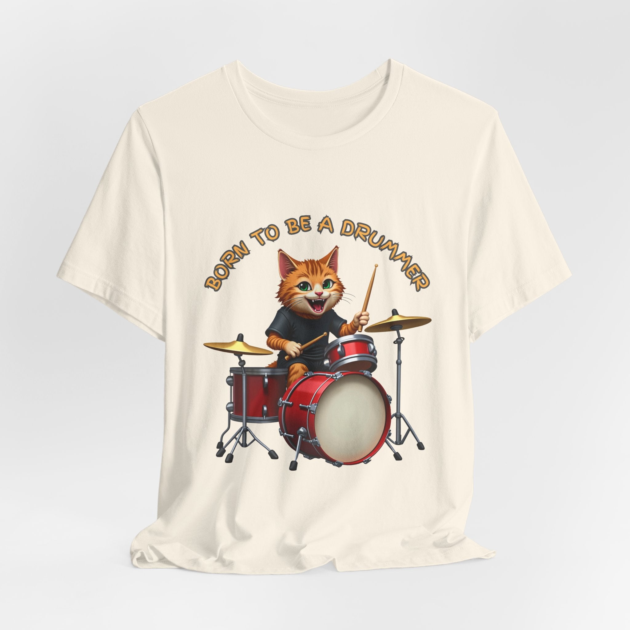 Beige t-shirt with a cartoon cat playing drums and 'Born to be a Drummer' text on a light gray background