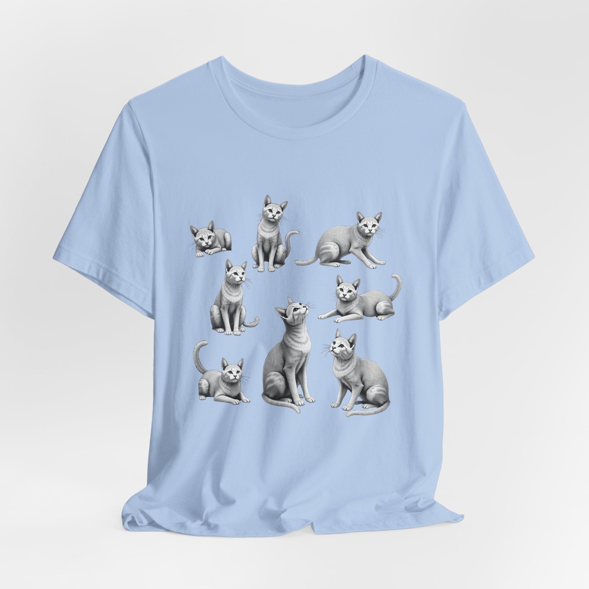 Light blue t-shirt with cat illustrations on a light gray background