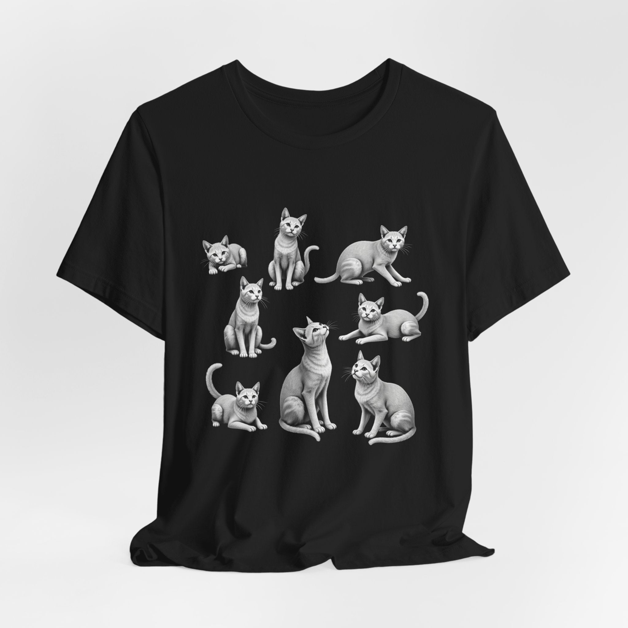 Black t-shirt with white cat illustrations on a light gray background