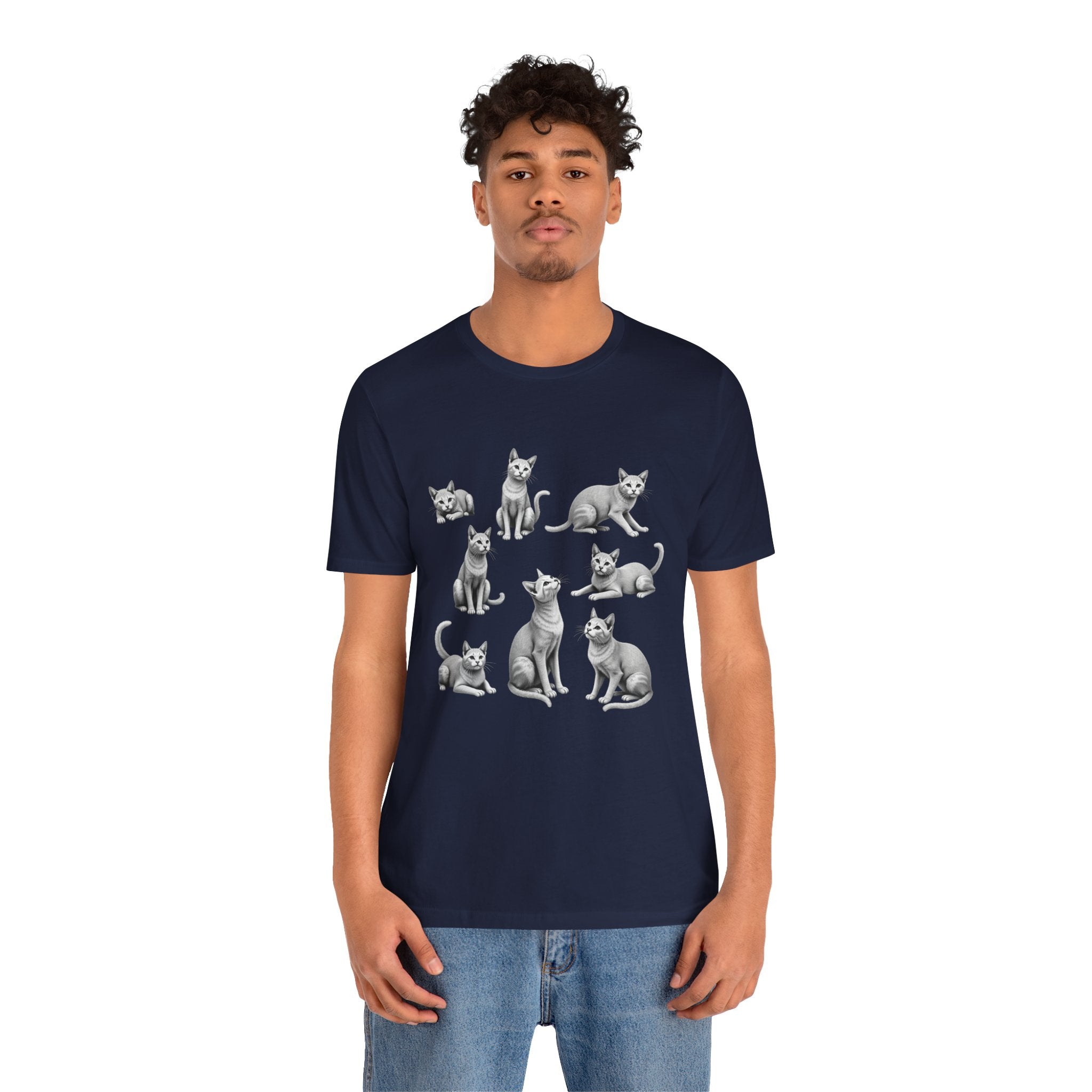 Person wearing a navy blue t-shirt with cat illustrations on a white background